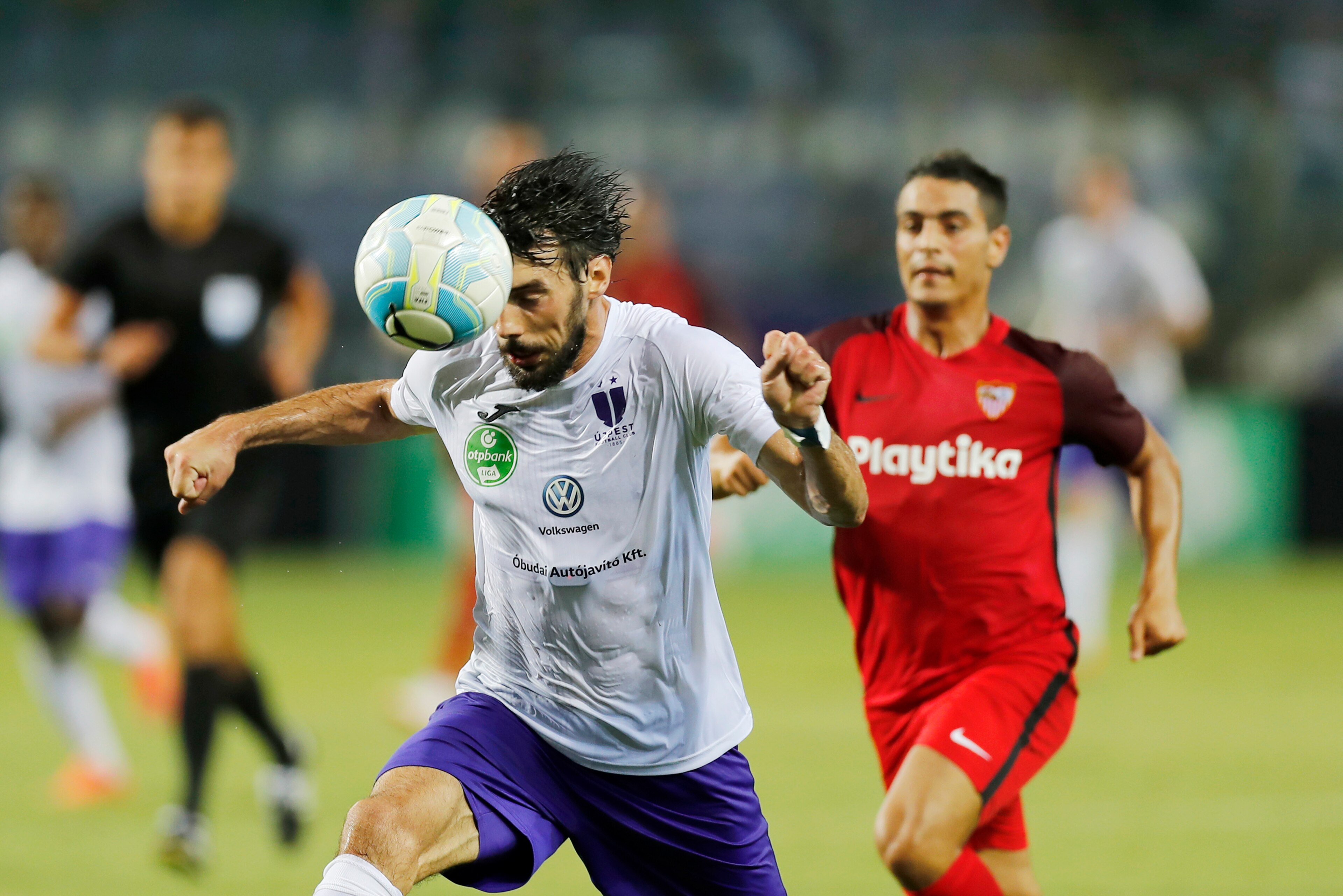 BUDAPEST, HUNGARY - AUGUST 2: (l-r) Mijusko Bojovic of Ujpest FC heads the ball in front of Wissam Ben Yedder of Sevilla FC during the UEFA Europa League Second Qualifying Round 2nd Leg match between Ujpest FC and Sevilla FC at Ferenc Szusza Stadium on Au