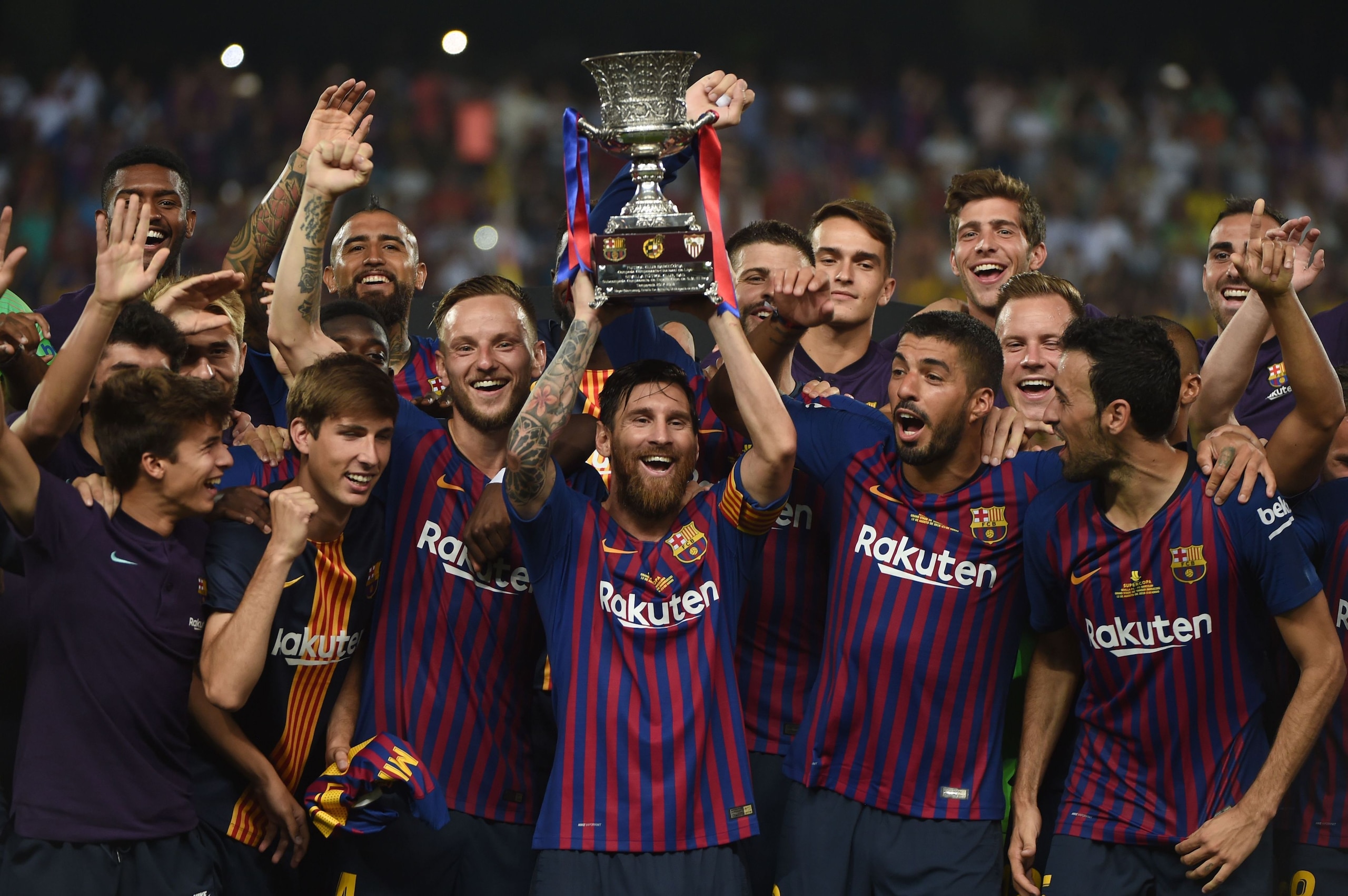 TOPSHOT - Barcelona's Argentinian forward Lionel Messi (C) carries the cup as they celebrate at the end of the Spanish Super Cup final between Sevilla FC and FC Barcelona at Ibn Batouta Stadium in the Moroccan city of Tangiers on August 12, 2018. - Barcel