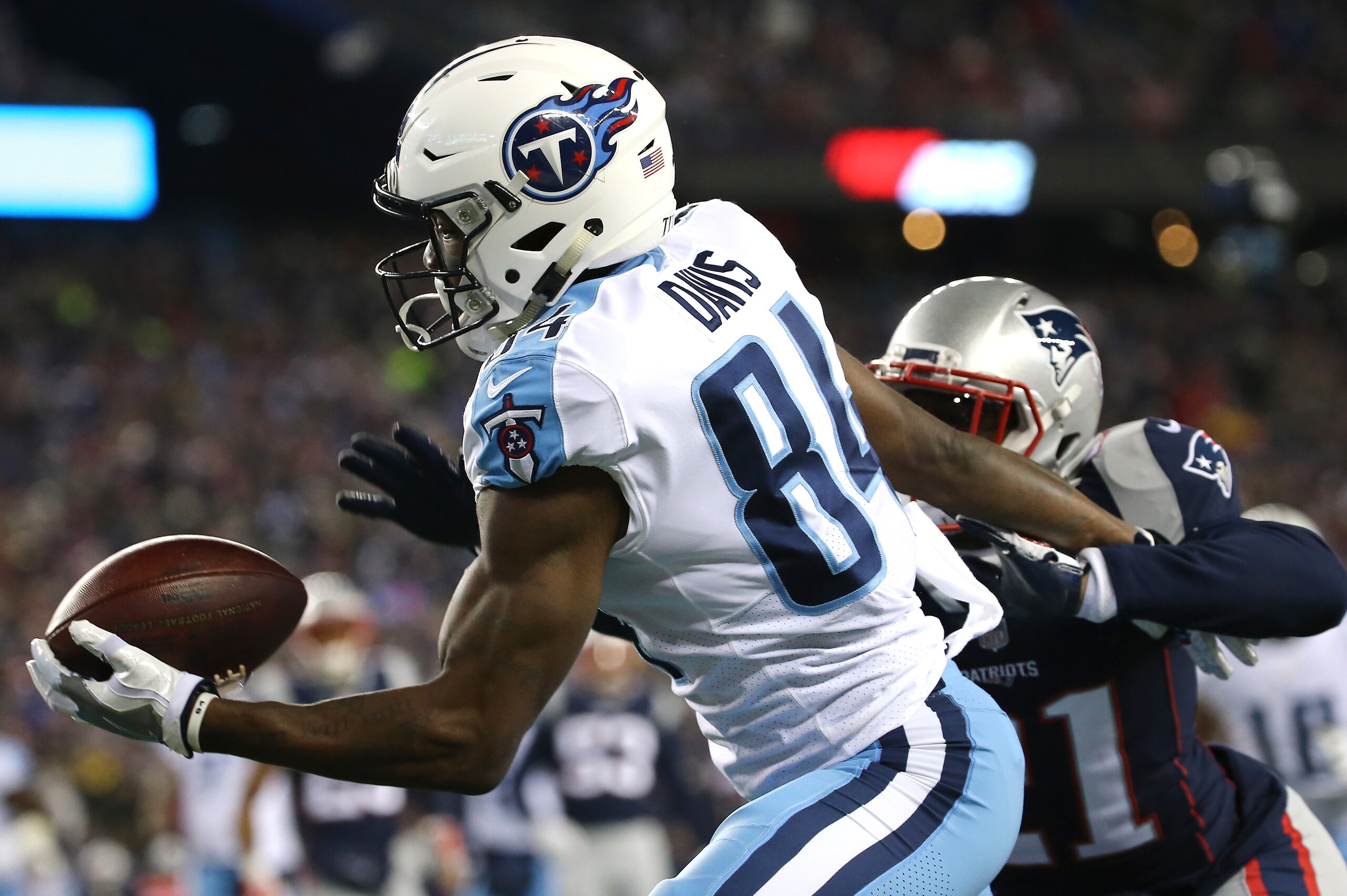 FOXBOROUGH, MA - JANUARY 13: Corey Davis #84 of the Tennessee Titans catches a touchdown pass as he is defended by Malcolm Butler #21 of the New England Patriots in the first quarter of the AFC Divisional Playoff game at Gillette Stadium on January 13, 20