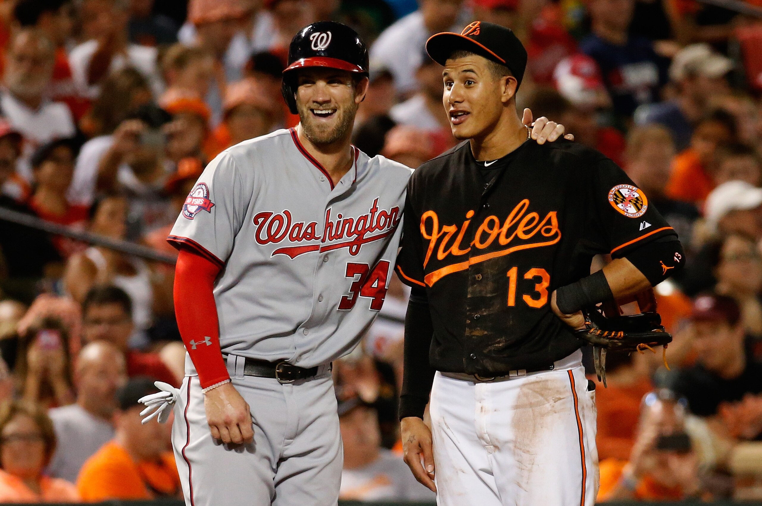 BALTIMORE, MD - JULY 10:  Bryce Harper #34 of the Washington Nationals and Manny Machado #13 of the Baltimore Orioles talk during their game at Oriole Park at Camden Yards on July 10, 2015 in Baltimore, Maryland.  (Photo by Rob Carr/Getty Images)