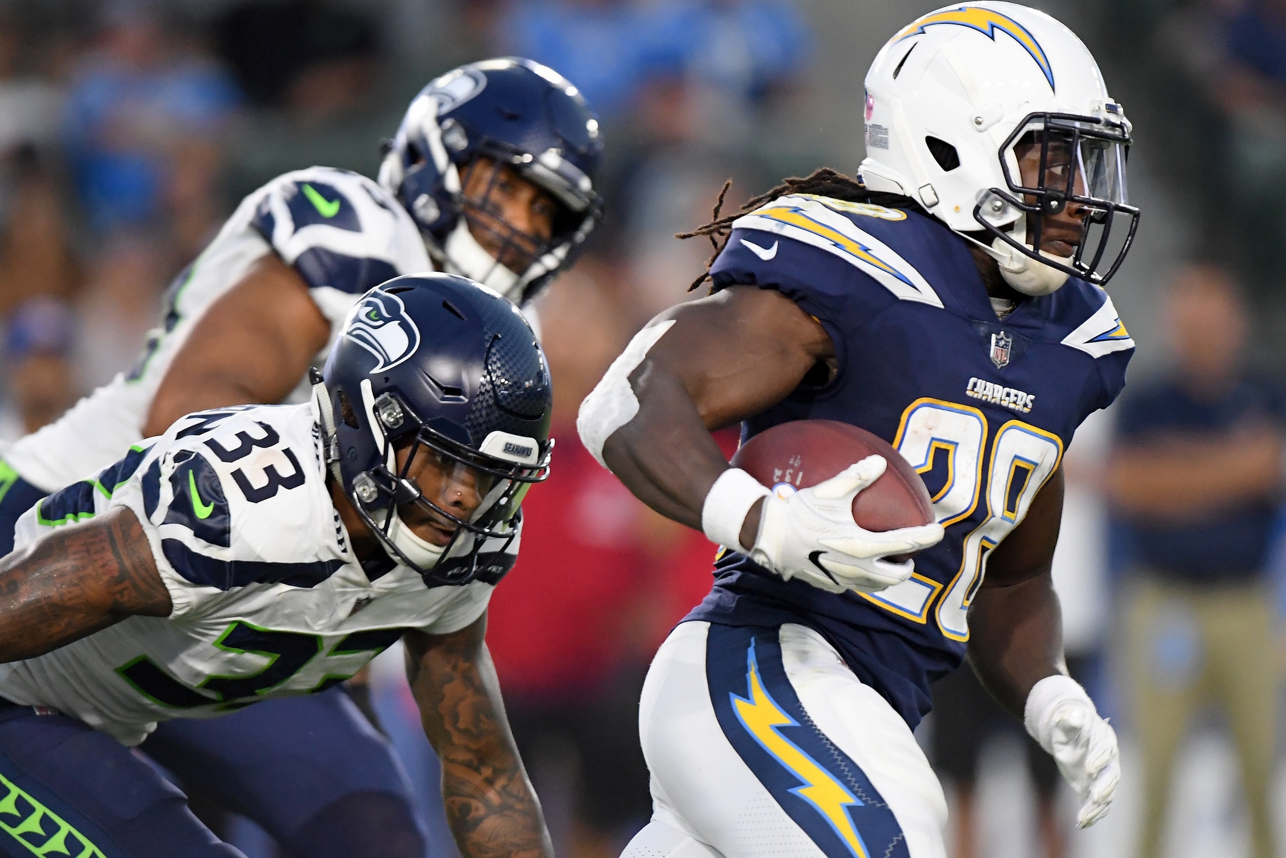 CARSON, CA - AUGUST 18:  Melvin Gordon #28 of the Los Angeles Chargers runs past Tedric Thompson #33 of the Seattle Seahawks during a presseason game at StubHub Center on August 18, 2018 in Carson, California.  (Photo by Harry How/Getty Images)