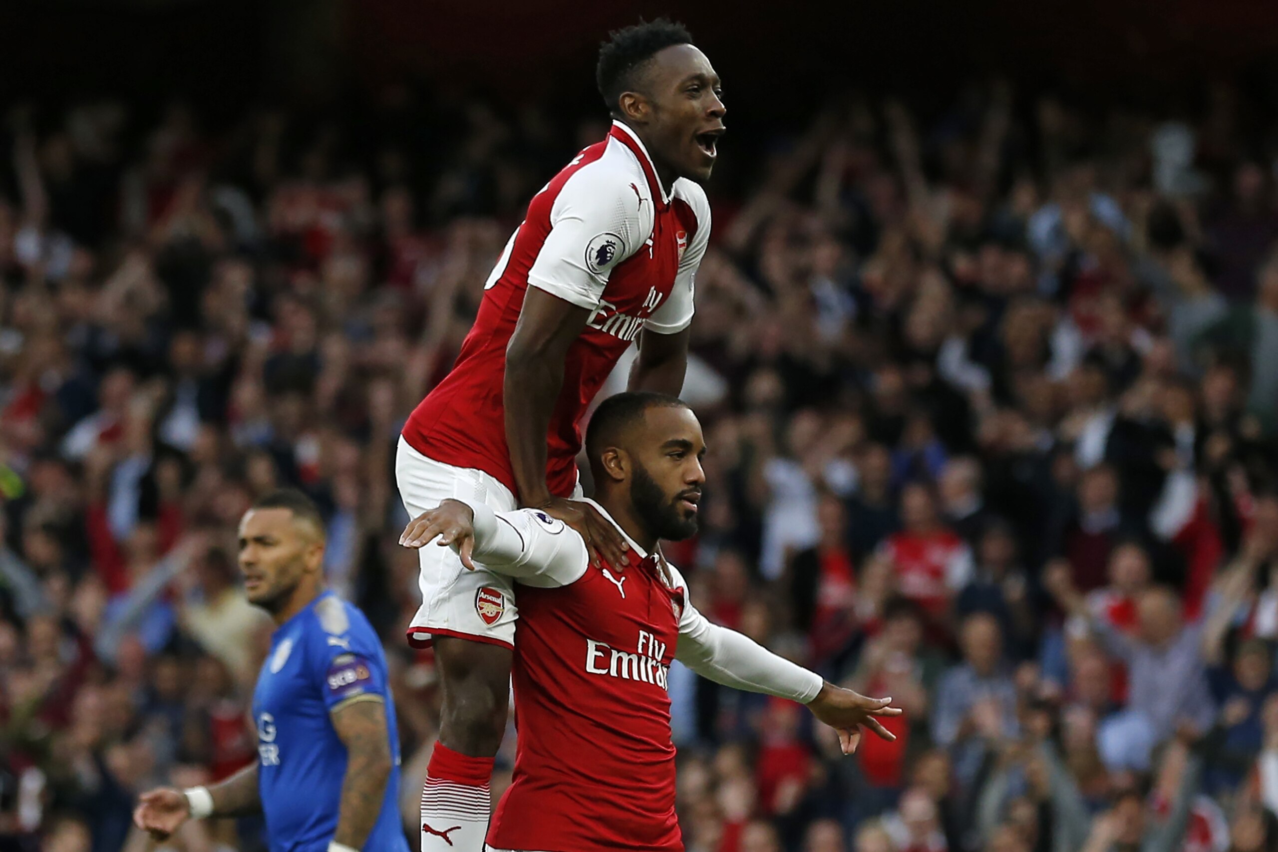 Arsenal's French striker Alexandre Lacazette celebrates with Arsenal's English striker Danny Welbeck (up) after scoring the opening goal of the English Premier League football match between Arsenal and Leicester City at the Emirates Stadium in London on A