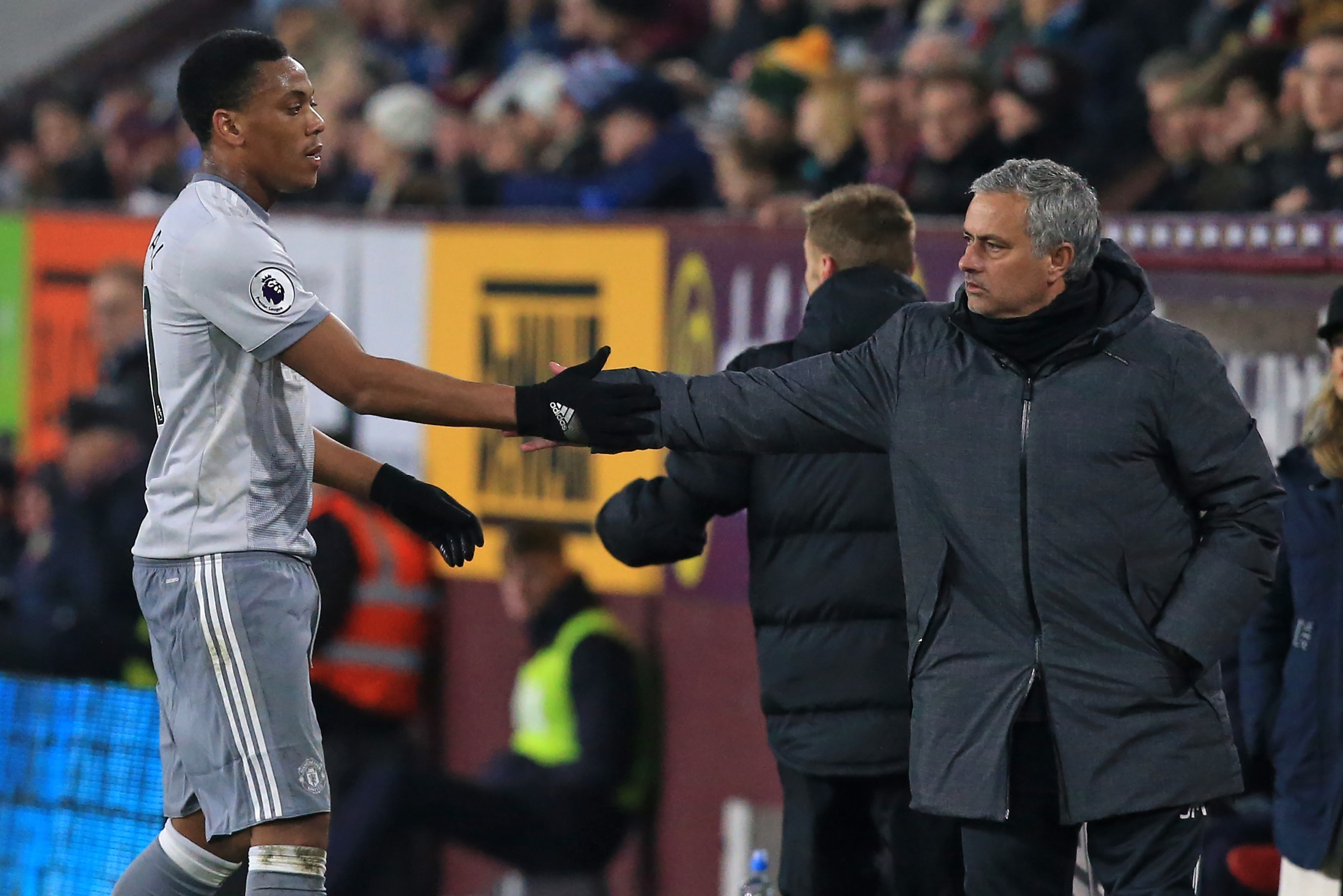 Goal-scorer Manchester United's French striker Anthony Martial (L) shakes hands with Manchester United's Portuguese manager Jose Mourinho after being substituted during the English Premier League football match between Burnley and Manchester United at Tur