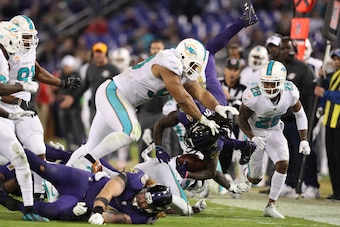 BALTIMORE, MD - OCTOBER 26: Running Back Alex Collins #34 of the Baltimore Ravens is tackled by defensive tackle Ndamukong Suh #93 of the Miami Dolphins in the fourth quarter at M&T Bank Stadium on October 26, 2017 in Baltimore, Maryland. (Photo by Rob Ca