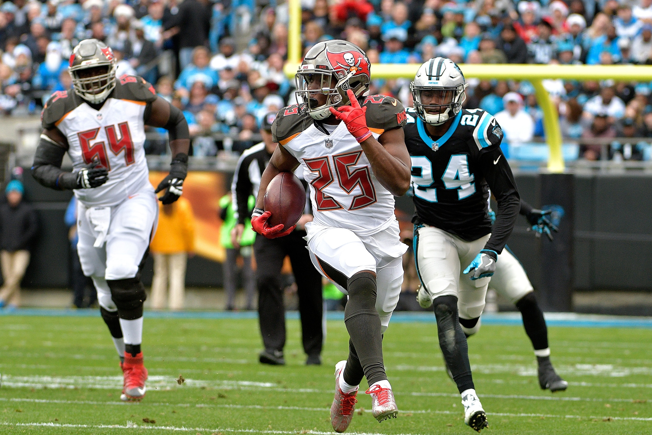 CHARLOTTE, NC - DECEMBER 24:  Peyton Barber #25 of the Tampa Bay Buccaneers runs the ball against the Carolina Panthers in the first quarter at Bank of America Stadium on December 24, 2017 in Charlotte, North Carolina.  (Photo by Grant Halverson/Getty Ima