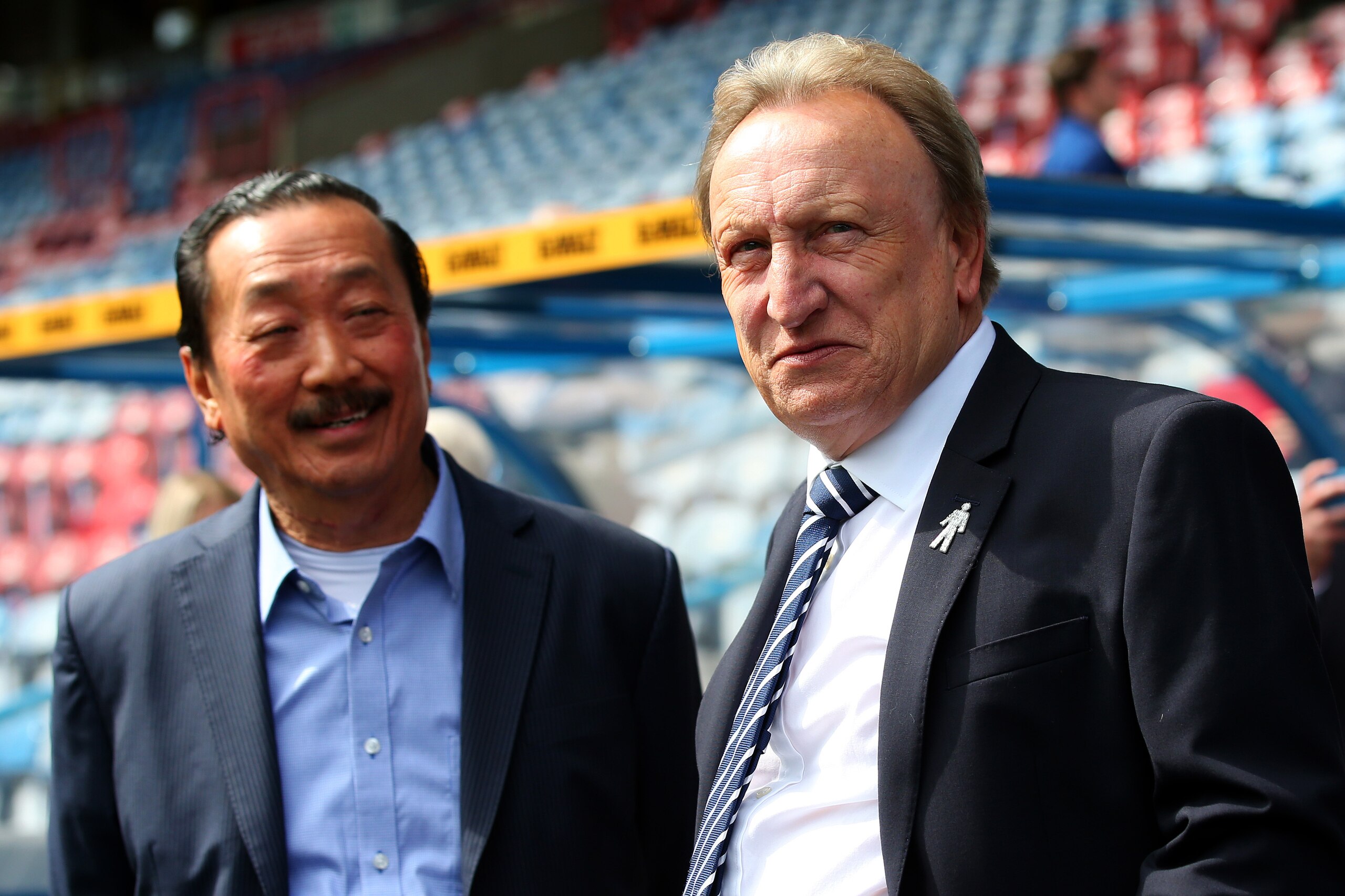HUDDERSFIELD, ENGLAND - AUGUST 25: Cardiff City owner Vincent Tan speaks with Neil Warnock, Manager of Cardiff City prior to the Premier League match between Huddersfield Town and Cardiff City at John Smith's Stadium on August 25, 2018 in Huddersfield, U HUDDERSFIELD, ENGLAND - AUGUST 25: Cardiff City owner Vincent Tan speaks with Neil Warnock, Manager of Cardiff City prior to the Premier League match between Huddersfield Town and Cardiff City at John Smith's Stadium on August 25, 2018 in Huddersfield, U