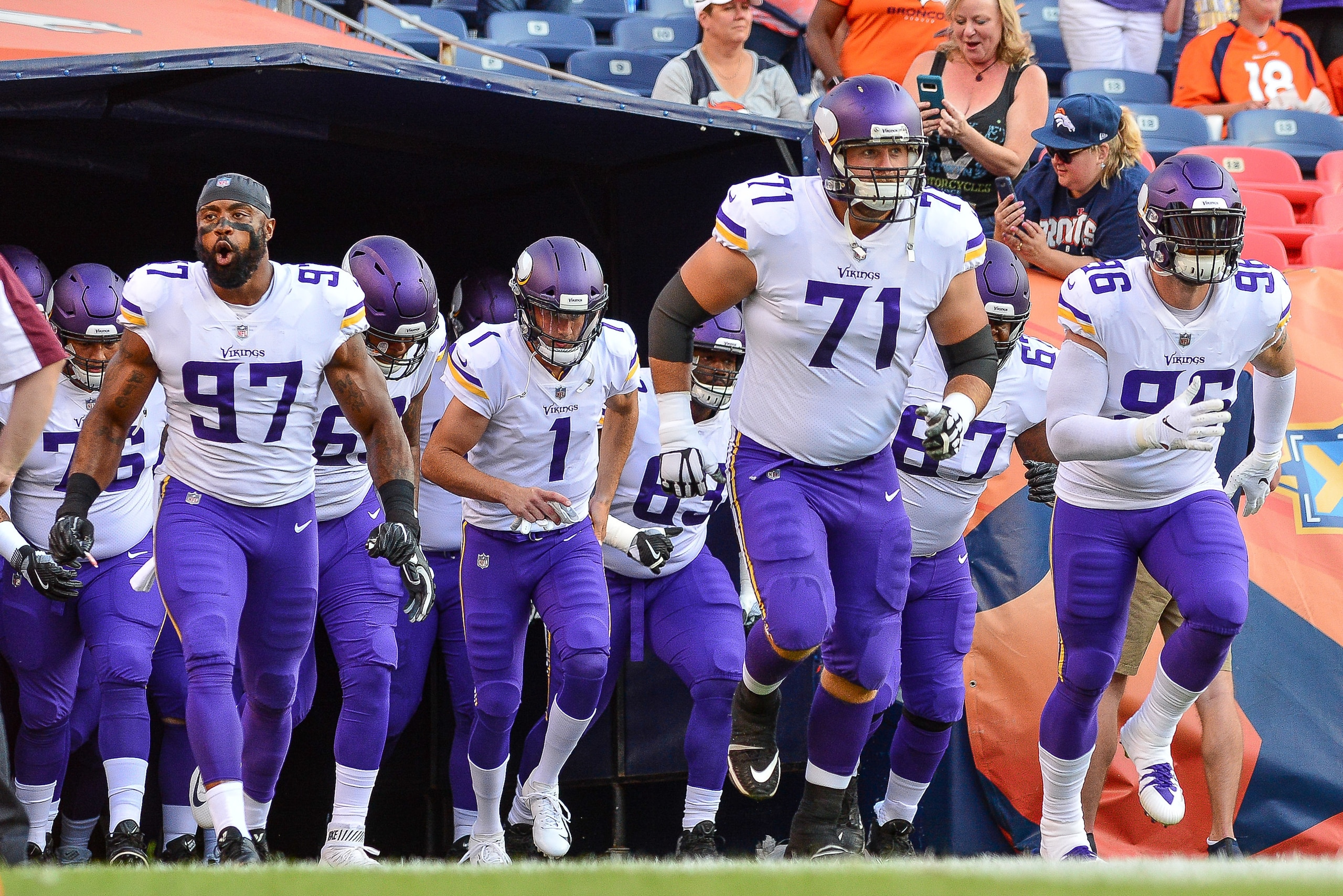 DENVER, CO - AUGUST 11:  Minnesota Vikings players, including defensive end Everson Griffen #97, quarterback Kyle Sloter #1, offensive tackle Riley Reiff #71, and defensive end Brian Robison #96 run onto the field during player introductions before an NFL