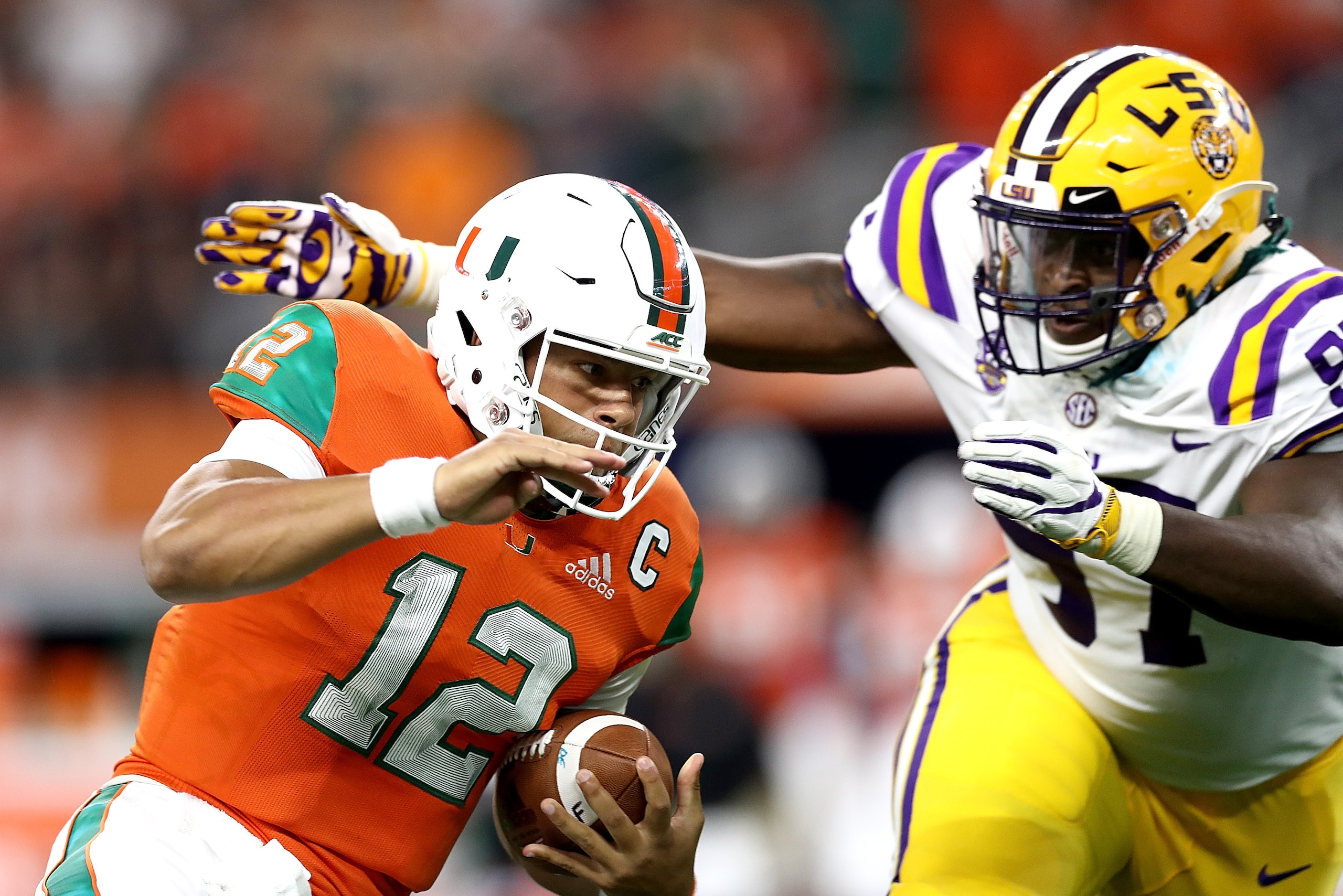 ARLINGTON, TX - SEPTEMBER 02:  Malik Rosier #12 of the Miami Hurricanes runs the ball against Glen Logan #97 of the LSU Tigers in the first quarter during the AdvoCare Classic at AT&T Stadium on September 2, 2018 in Arlington, Texas.  (Photo by Ronald Mar