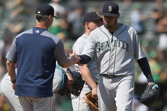 OAKLAND, CA - SEPTEMBER 02:  Manager Scott Servais #29 of the Seattle Mariners takes the ball from Felix Hernandez #34 taking Hernandez out of the game against the Oakland Athletics in the bottom of the six inning at Oakland Alameda Coliseum on September 