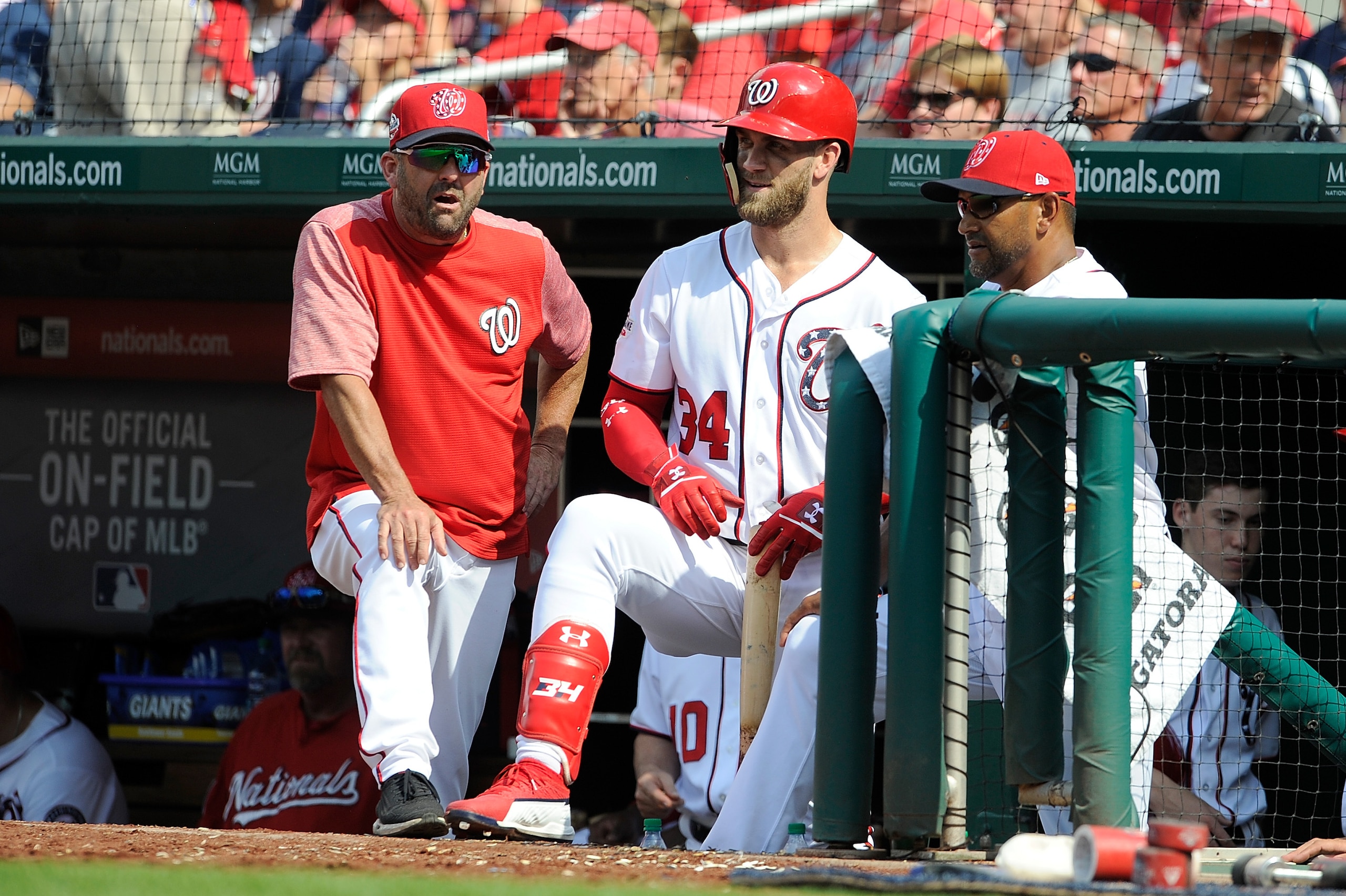 WASHINGTON, DC - AUGUST 05:  Bryce Harper #34 of the Washington Nationals talks with hitting coach Kevin Long #54 and manager Dave Martinez #4 during a pitching change in the eighth inning against the Cincinnati Reds at Nationals Park on August 5, 2018 in