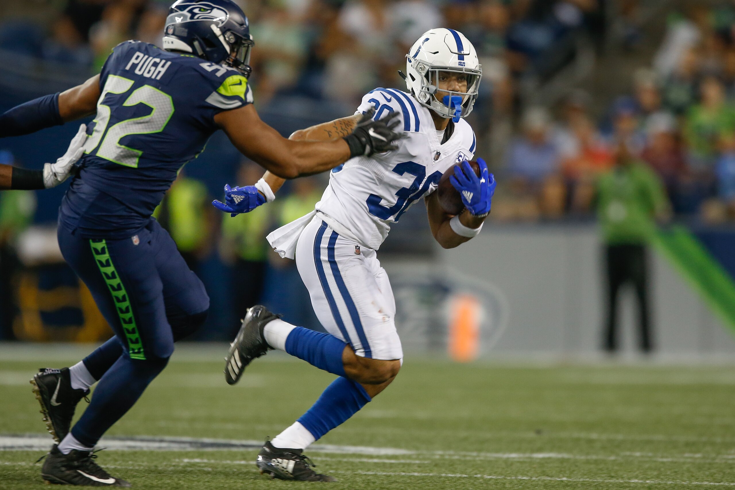 SEATTLE, WA - AUGUST 09:  Running back Jordan Wilkins #30 of the Indianapolis Colts rushes against linebacker Jake Pugh #52 of the Seattle Seahawks at CenturyLink Field on August 9, 2018 in Seattle, Washington.  (Photo by Otto Greule Jr/Getty Images)