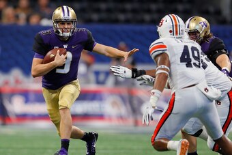 ATLANTA, GA - SEPTEMBER 01:  Jake Browning #3 of the Washington Huskies rushes away from Darrell Williams #49 and Andrew Williams #79 of the Auburn Tigers at Mercedes-Benz Stadium on September 1, 2018 in Atlanta, Georgia.  (Photo by Kevin C. Cox/Getty Ima