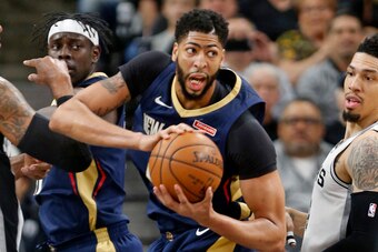 SAN ANTONIO,TX - FEBRUARY 28 : Anthony Davis #23 of the New Orleans Pelicans looks to make an outlet pass after grabbing a rebound between LaMarcus Aldridge #12 and Danny Green #14 of the San Antonio Spurs  at AT&T Center on February 28, 2018  in San Anto