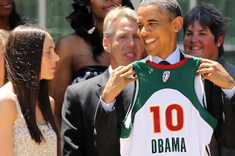 WASHINGTON - JUNE 29:  U.S. President Barack Obama (2nd R) receives a jersey from guard Sue Bird (L) of the Seattle Storm Coach Brian Agler (2nd L) looks on during a Rose Garden event June 29, 2011 at the White House in Washington, DC. Obama hosted the WN