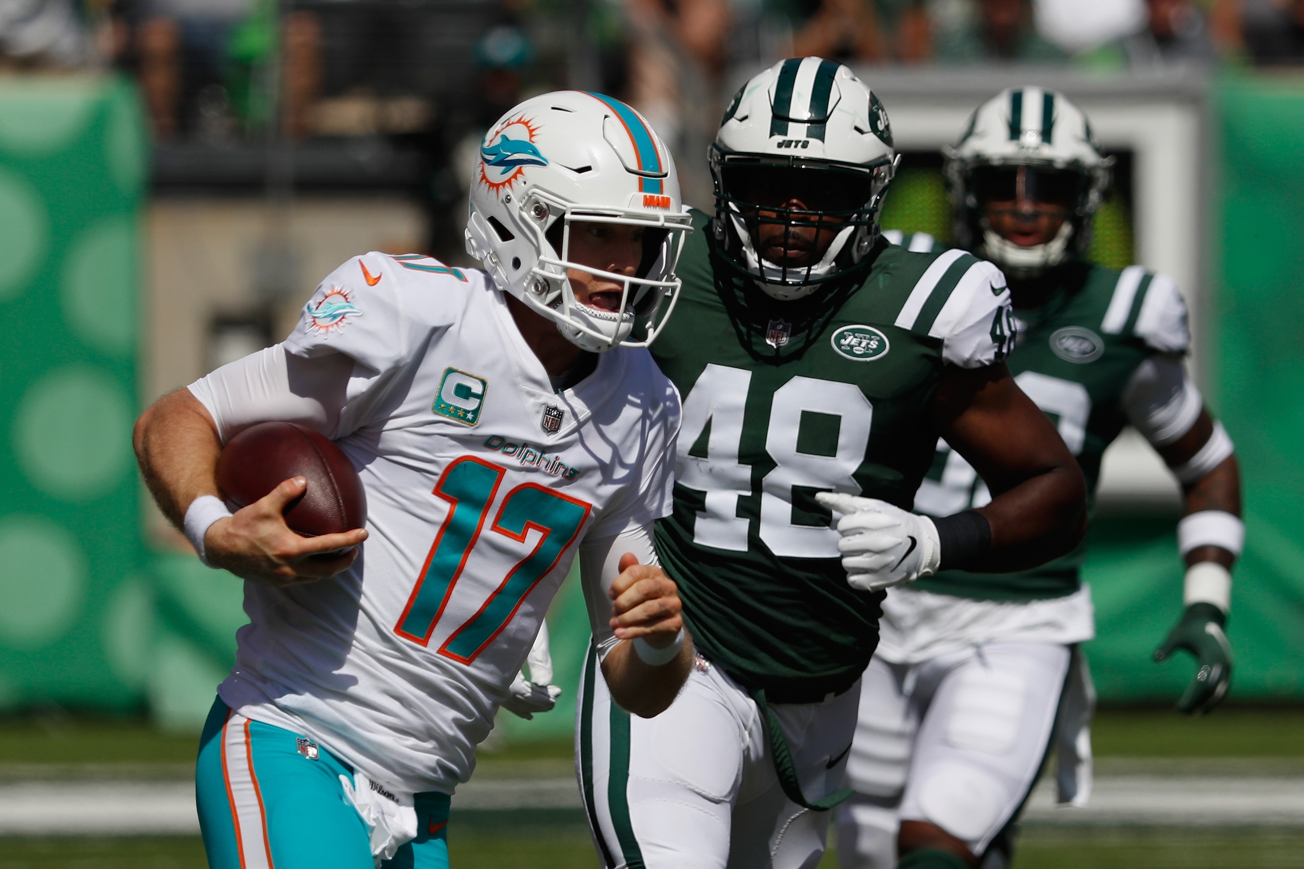 EAST RUTHERFORD, NJ - SEPTEMBER 16:  Quarterback Ryan Tannehill #17 of the Miami Dolphins runs the ball against linebacker Jordan Jenkins #48 of the New York Jets during the first quarter at MetLife Stadium on September 16, 2018 in East Rutherford, New Je