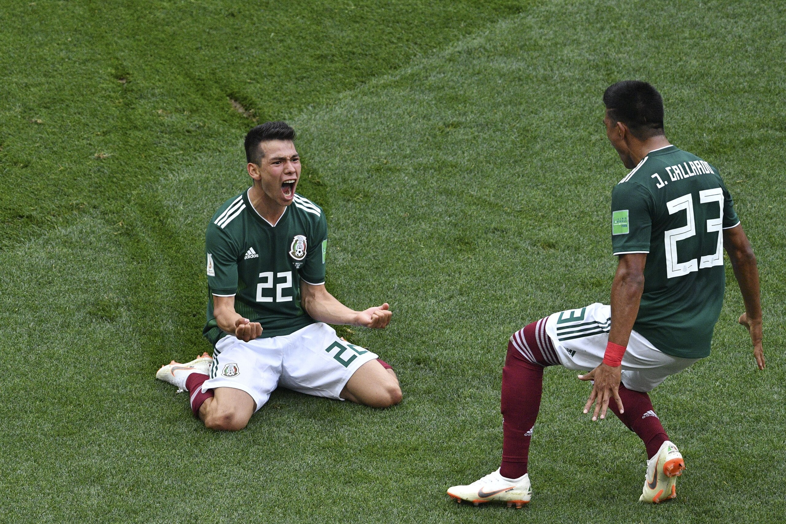 TOPSHOT - Mexico's forward Hirving Lozano (L) celebrates after scoring during the Russia 2018 World Cup Group F football match between Germany and Mexico at the Luzhniki Stadium in Moscow on June 17, 2018. (Photo by Mladen ANTONOV / AFP) / RESTRICTED TO E
