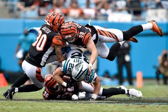 CHARLOTTE, NC - SEPTEMBER 23:  Jessie Bates #30, Shawn Williams #36 and Nick Vigil #59 of the Cincinnati Bengals tackle Christian McCaffrey #22 of the Carolina Panthers during their game at Bank of America Stadium on September 23, 2018 in Charlotte, North