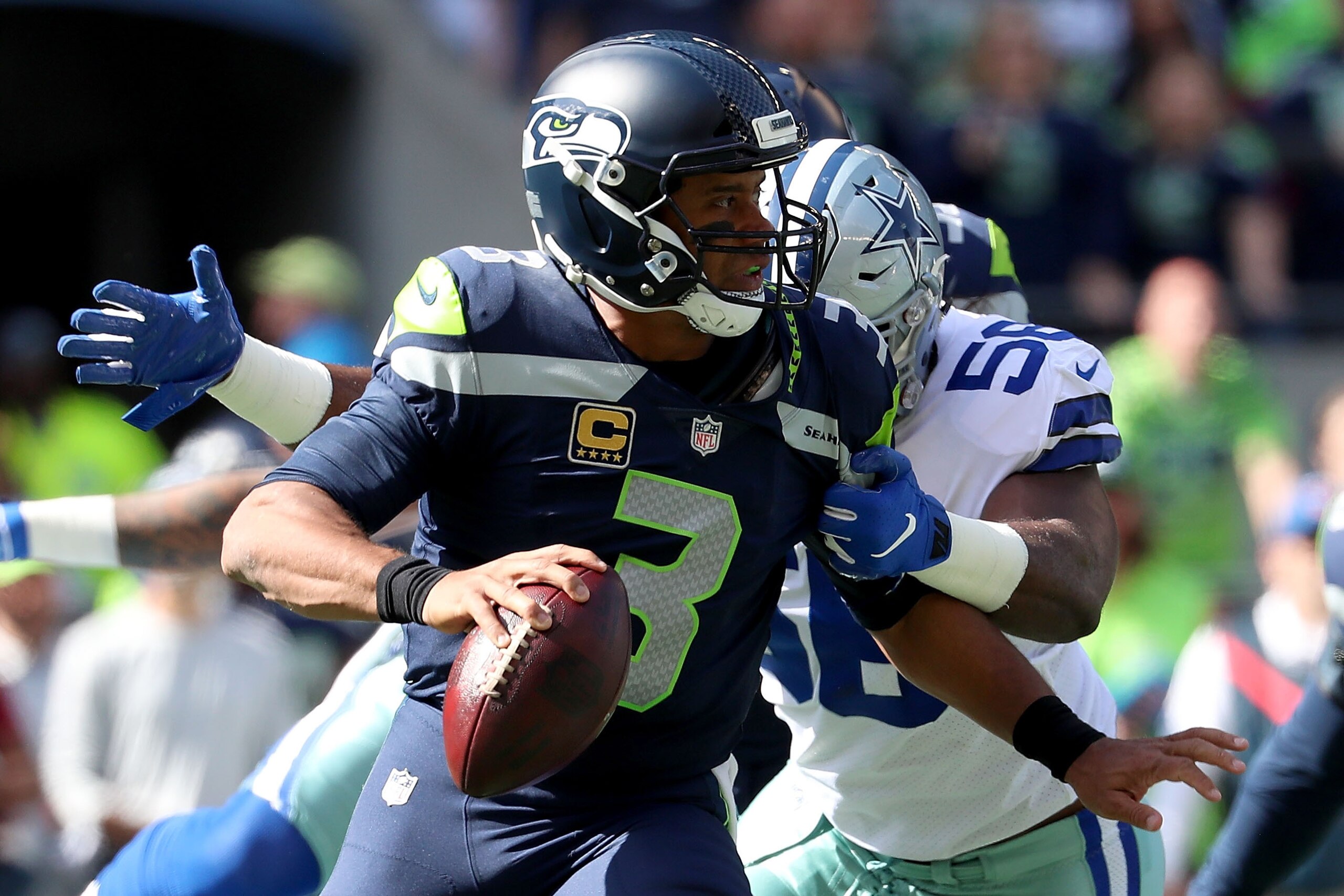 SEATTLE, WA - SEPTEMBER 23: Russell Wilson #3 of the Seattle Seahawks looks to throw the ball against Datone Jones #56 of the Dallas Cowboys in the first quarter during their game at CenturyLink Field on September 23, 2018 in Seattle, Washington.  (Photo 