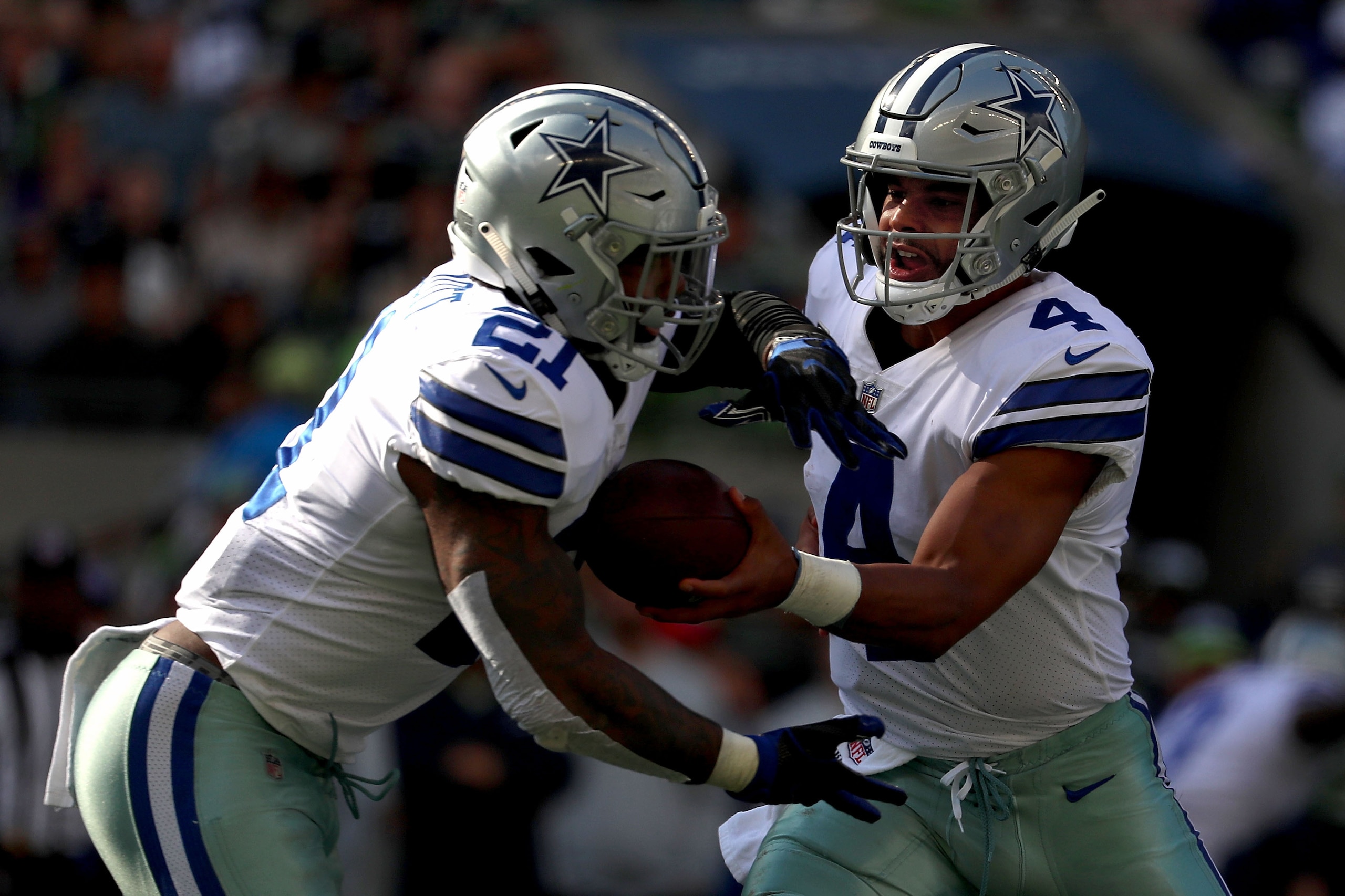 SEATTLE, WA - SEPTEMBER 23: Dak Prescott #4 hands the ball off to Ezekiel Elliott #21 of the Dallas Cowboys in the third quarter during their game at CenturyLink Field on September 23, 2018 in Seattle, Washington.  (Photo by Abbie Parr/Getty Images)