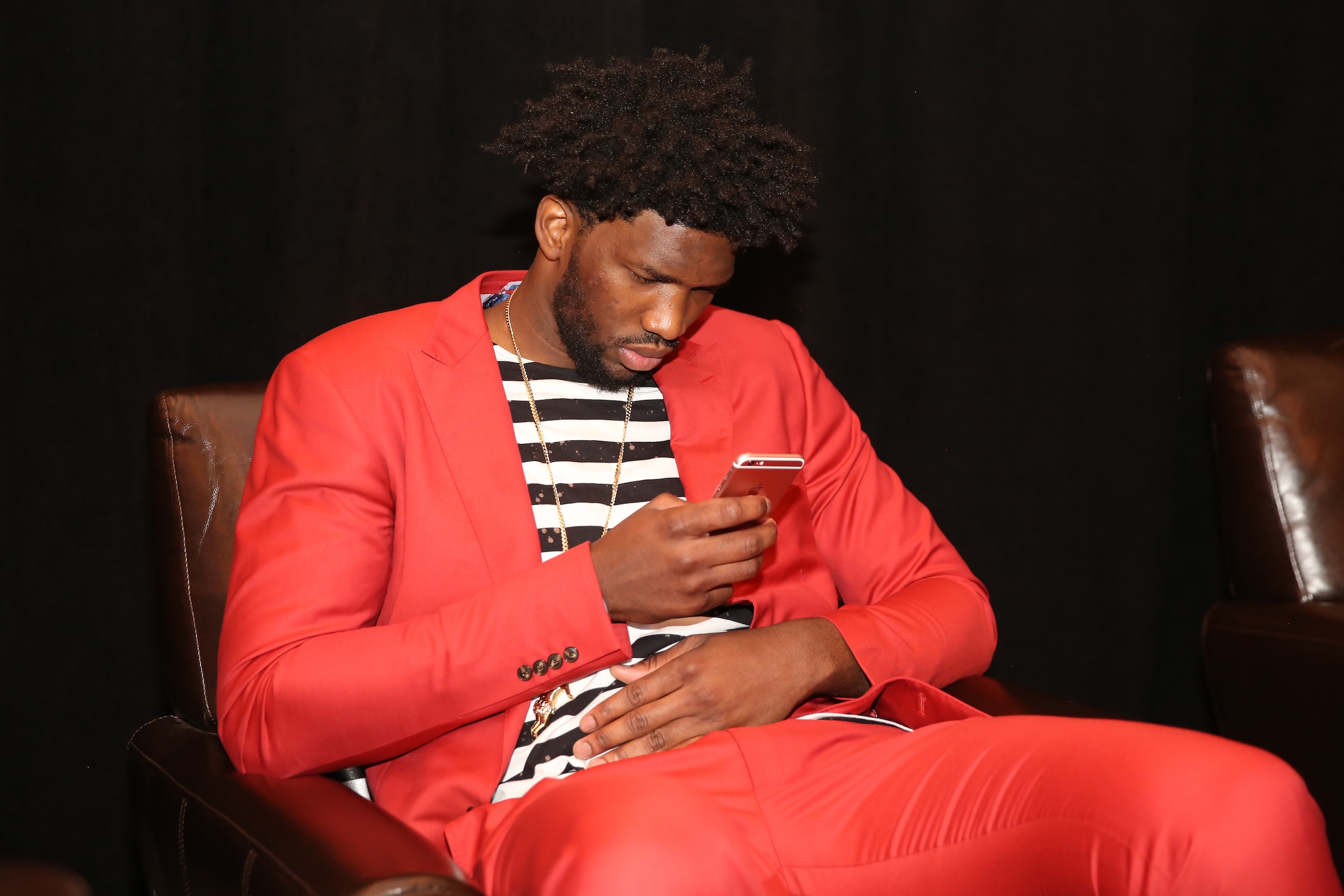 NEW YORK, NEW YORK - MAY 16:  Joel Embiid #21 of the Philadelphia 76ers looks on his phone during the 2017 NBA Draft Lottery at the New York Hilton in New York, New York. NOTE TO USER: User expressly acknowledges and agrees that, by downloading and or usi