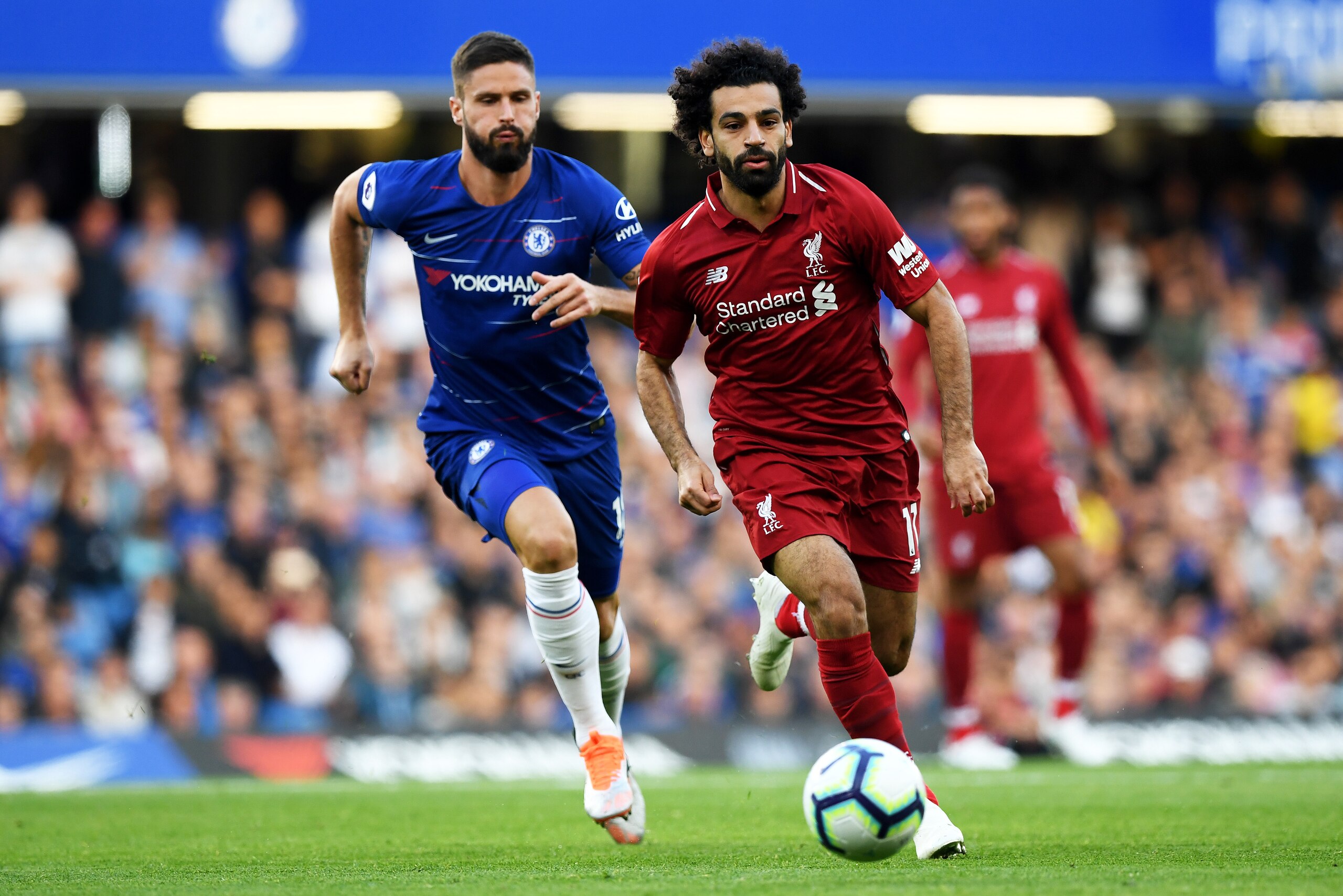 LONDON, ENGLAND - SEPTEMBER 29:  Mohamed Salah of Liverpool runs with the ball away from Olivier Giroud of Chelsea during the Premier League match between Chelsea FC and Liverpool FC at Stamford Bridge on September 29, 2018 in London, United Kingdom.  (Ph
