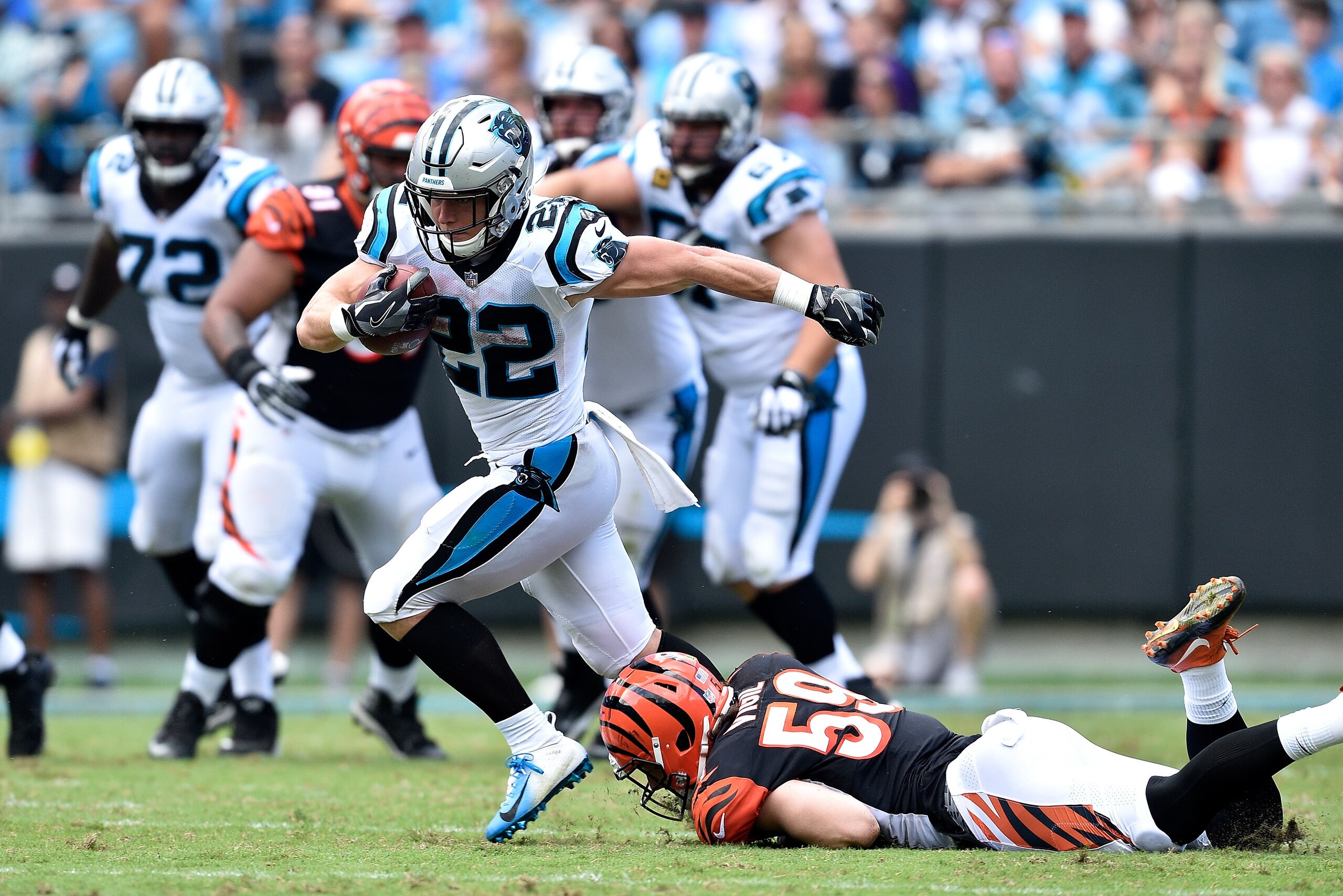 CHARLOTTE, NC - SEPTEMBER 23:  Christian McCaffrey #22 of the Carolina Panthers runs the ball against Nick Vigil #59 of the Cincinnati Bengals in the fourth quarter during their game at Bank of America Stadium on September 23, 2018 in Charlotte, North Car