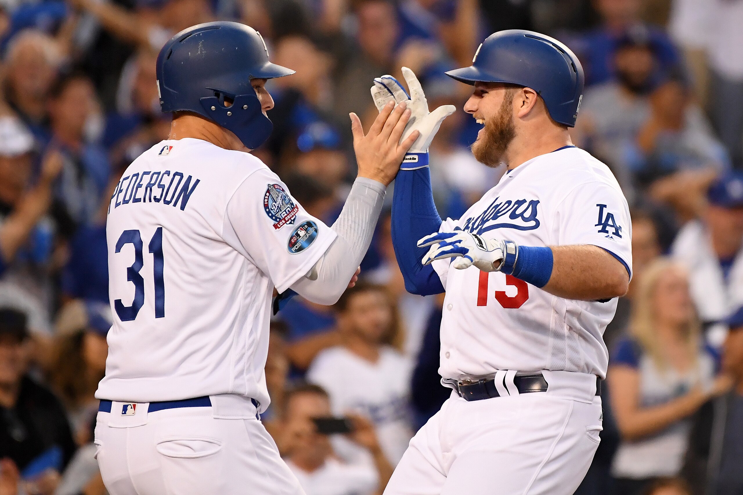 LOS ANGELES, CA - OCTOBER 04:  Max Muncy #13 of the Los Angeles Dodgers is congratulated by his teammate Joc Pederson #31 after his second inning 3 RBI home run against the Atlanta Braves during Game One of the National League Division Series at Dodger St