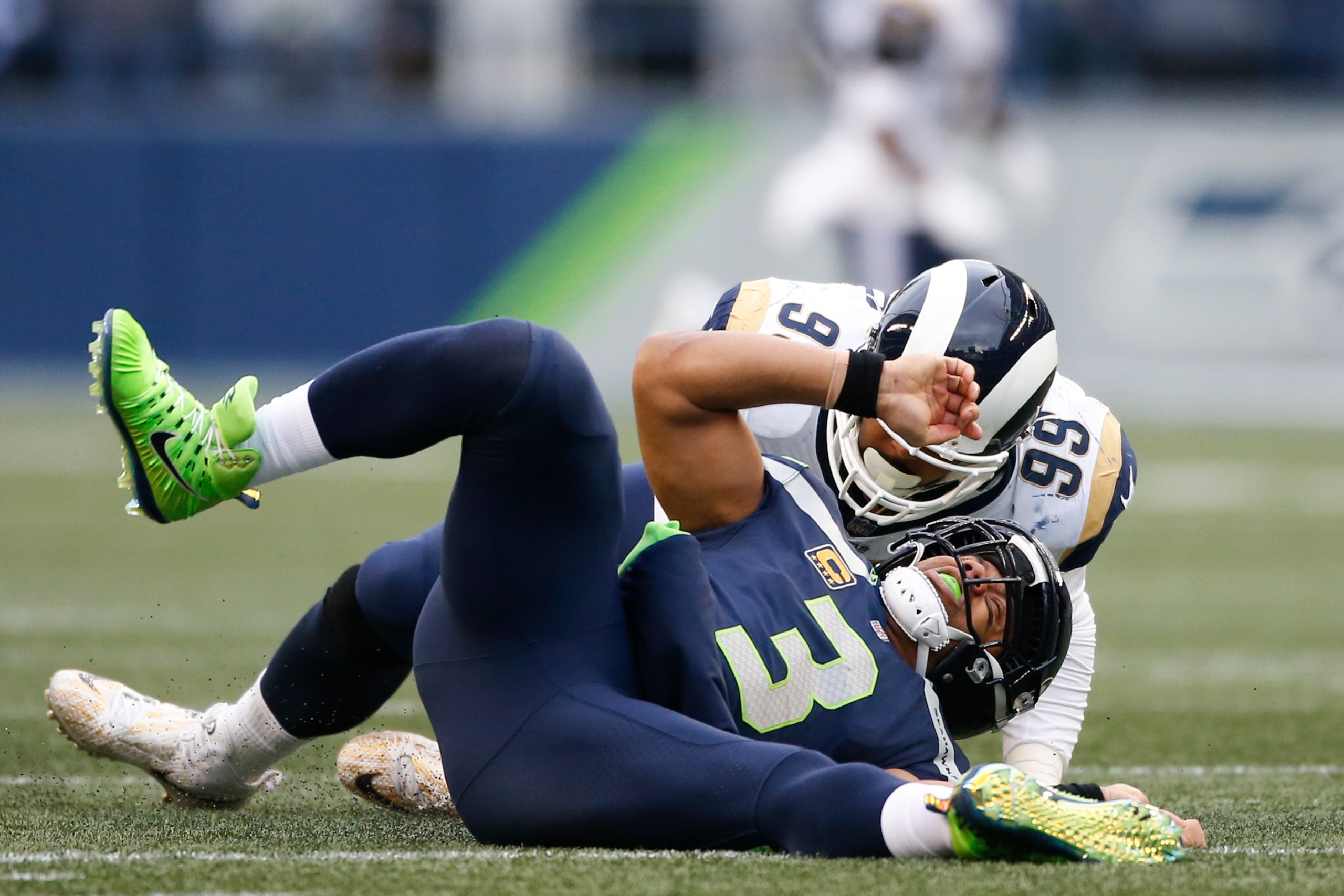 SEATTLE, WA - DECEMBER 17:  Quarterback Russell Wilson #3 of the Seattle Seahawks is sacked by defensive tackle Aaron Donald #99 of the Los Angeles Rams in the second quarter at CenturyLink Field on December 17, 2017 in Seattle, Washington.  (Photo by Ott