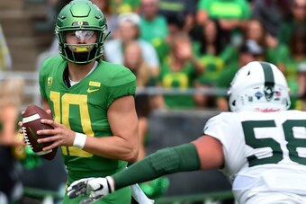 EUGENE, OR - SEPTEMBER 08: Justin Herbert #10 of the Oregon Ducks drops back to pass as defensive tackle Dallas House #58 of the Portland State Vikings apples pressure during the first half of the game against at Autzen Stadium on September 8, 2018 in Eug