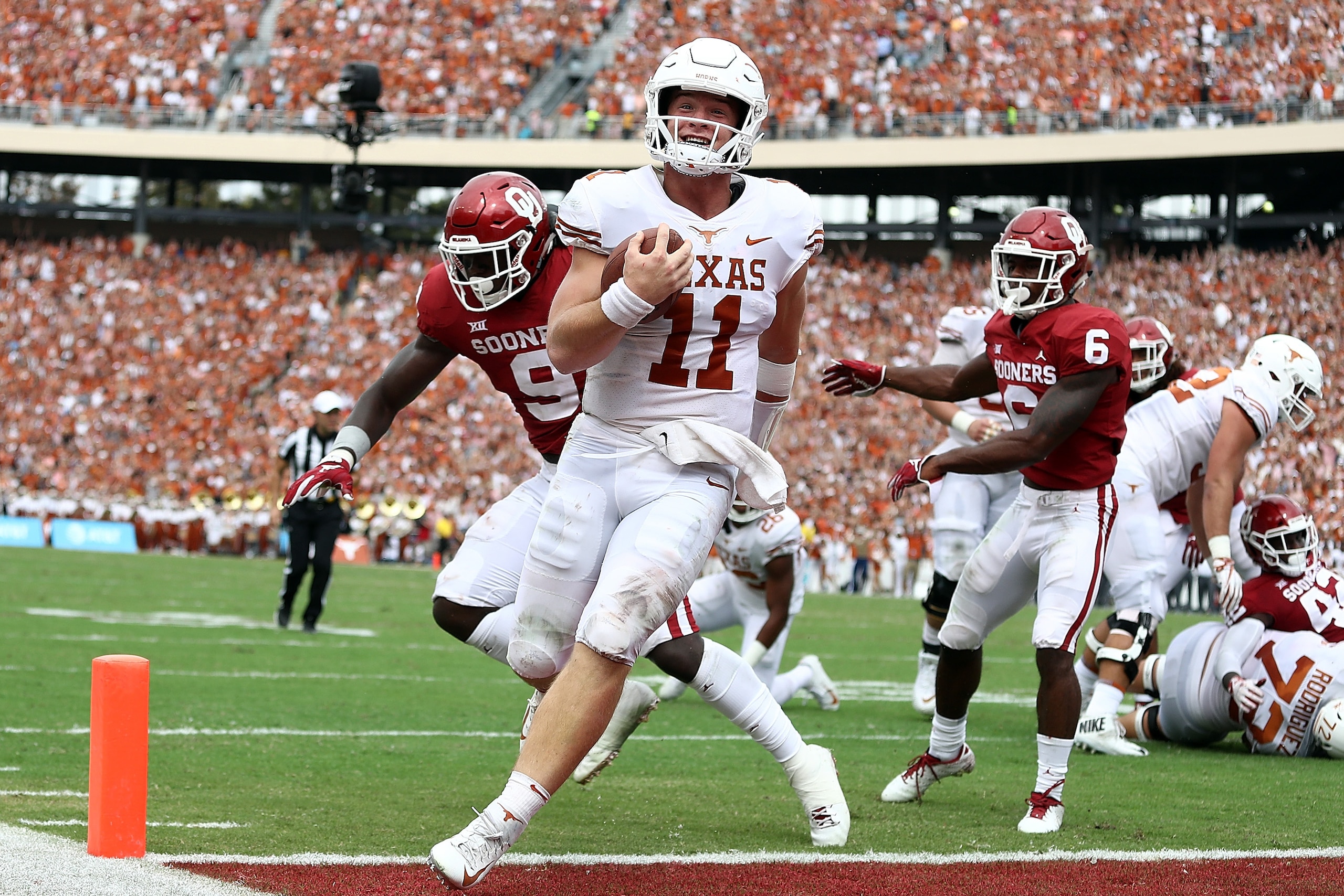 DALLAS, TX - OCTOBER 06:  Sam Ehlinger #11 of the Texas Longhorns smiles as he runs into the endzone for a touchdown against the Oklahoma Sooners in the second quarter of the 2018 AT&T Red River Showdown at Cotton Bowl on October 6, 2018 in Dallas, Texas.
