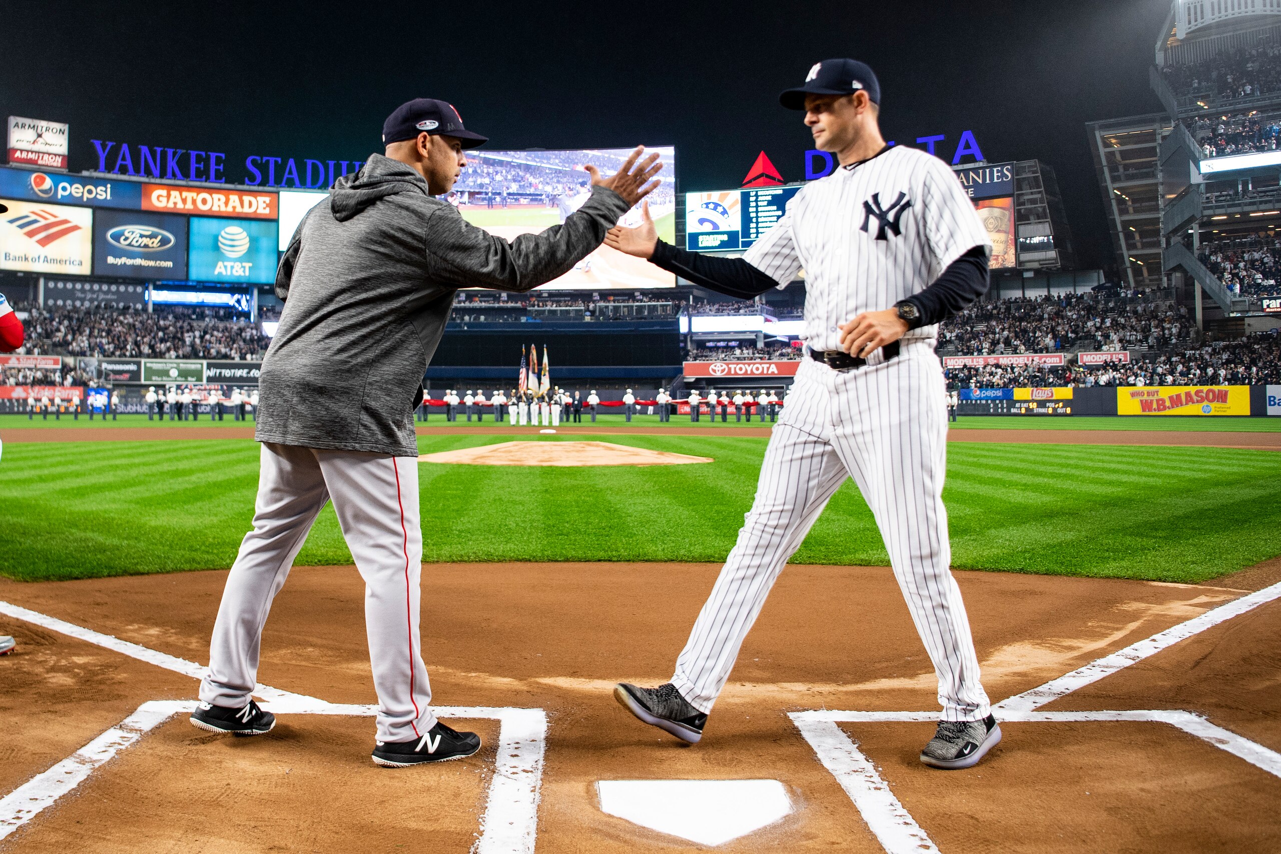NEW YORK, NY - OCTOBER 8: Manager Alex Cora of the Boston Red Sox shakes hands with Manager Aaron Boone of the New York Yankees before game three of the American League Division Series on October 8, 2018 at Yankee Stadium in the Bronx borough of New York 