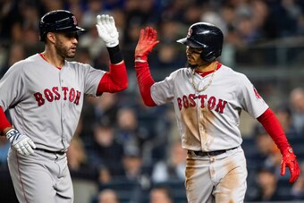 NEW YORK, NY - OCTOBER 8: Mookie Betts #50 of the Boston Red Sox high fives J.D. Martinez #28 after scoring on a sacrifice fly during the third inning of game three of the American League Division Series against the New York Yankees on October 8, 2018 at 