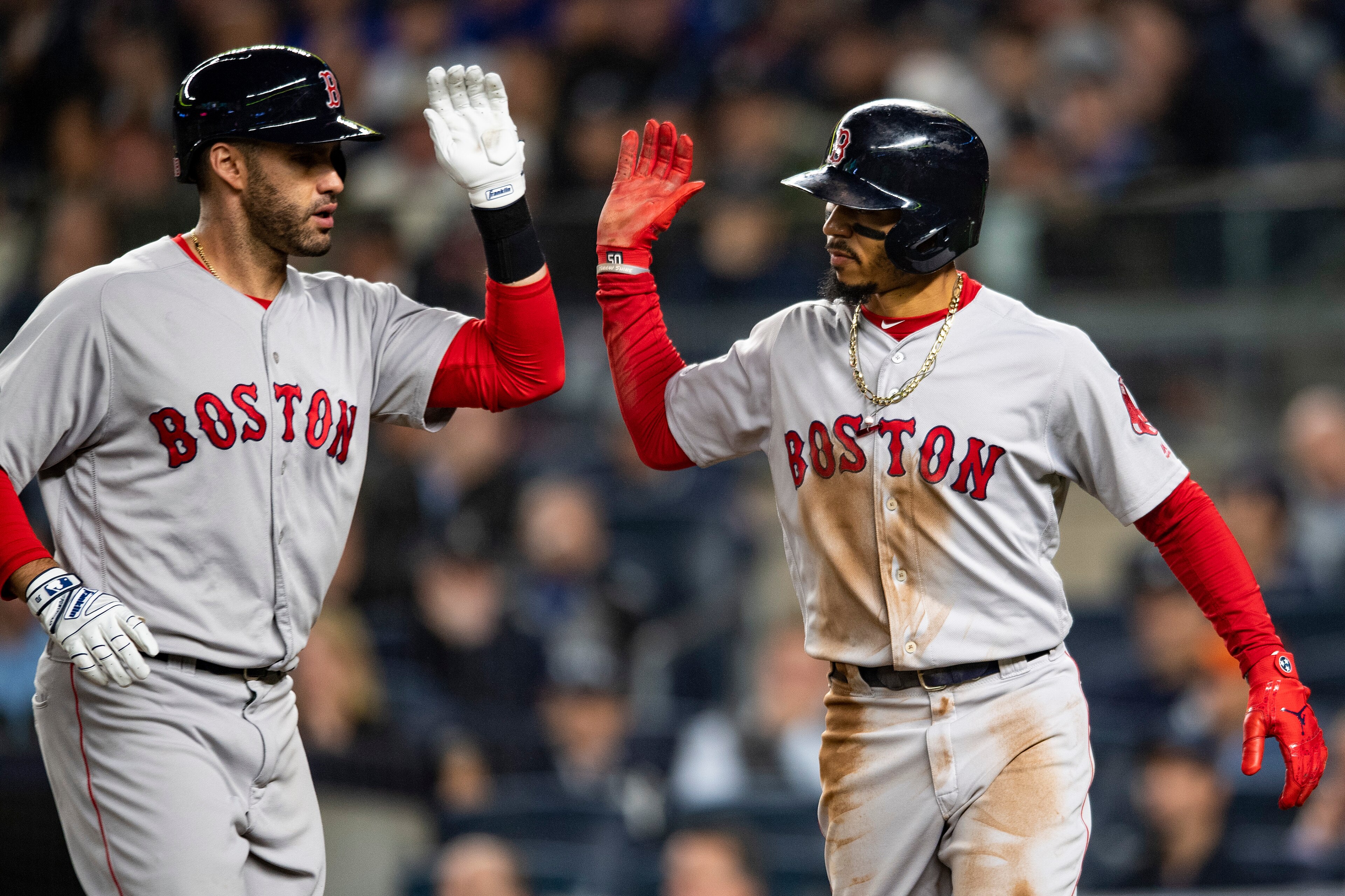 NEW YORK, NY - OCTOBER 8: Mookie Betts #50 of the Boston Red Sox high fives J.D. Martinez #28 after scoring on a sacrifice fly during the third inning of game three of the American League Division Series against the New York Yankees on October 8, 2018 at 