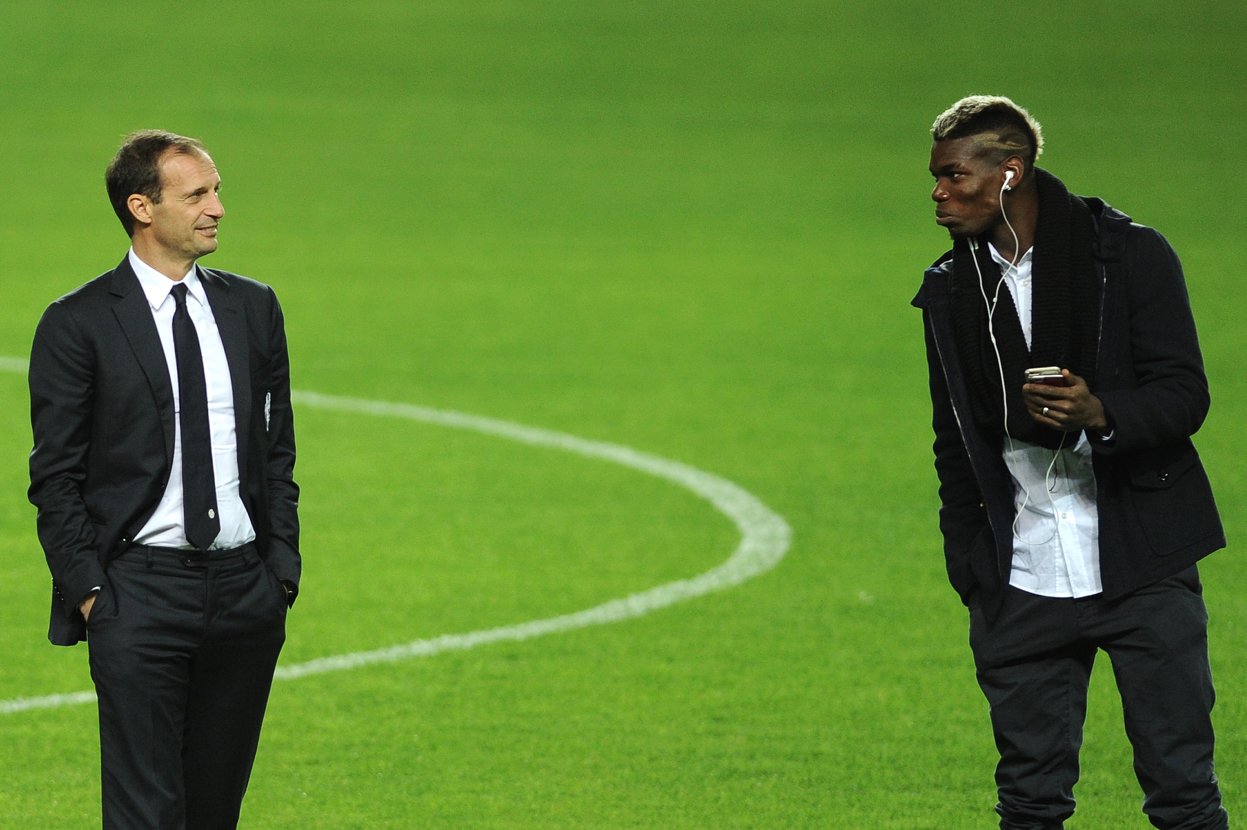 Juventus's French midfielder Paul Pogba (R) speaks with Juventus's coach Italian Massimiliano Allegri (L) at the Ramon Sanchez Pizjuan in Sevilla on December 7, 2015, on the eve of the UEFA Champions League Group D football match Sevilla FC vs Juventus.  