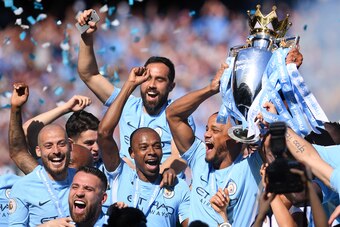 MANCHESTER, ENGLAND - MAY 06:  Vincent Kompany of Manchester City lifts the Premier League Trophy alongside David Silva, Nicolas Otamendi and Fernandinho as Manchester City celebrate winning the Premier League Title during the Premier League match between