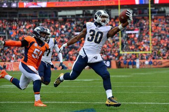 DENVER, CO - OCTOBER 14:  Running back Todd Gurley #30 of the Los Angeles Rams scores a second quarter rushing touchdown as linebacker Todd Davis #51 of the Denver Broncos attempts to tackle him during a game at Broncos Stadium at Mile High on October 14,