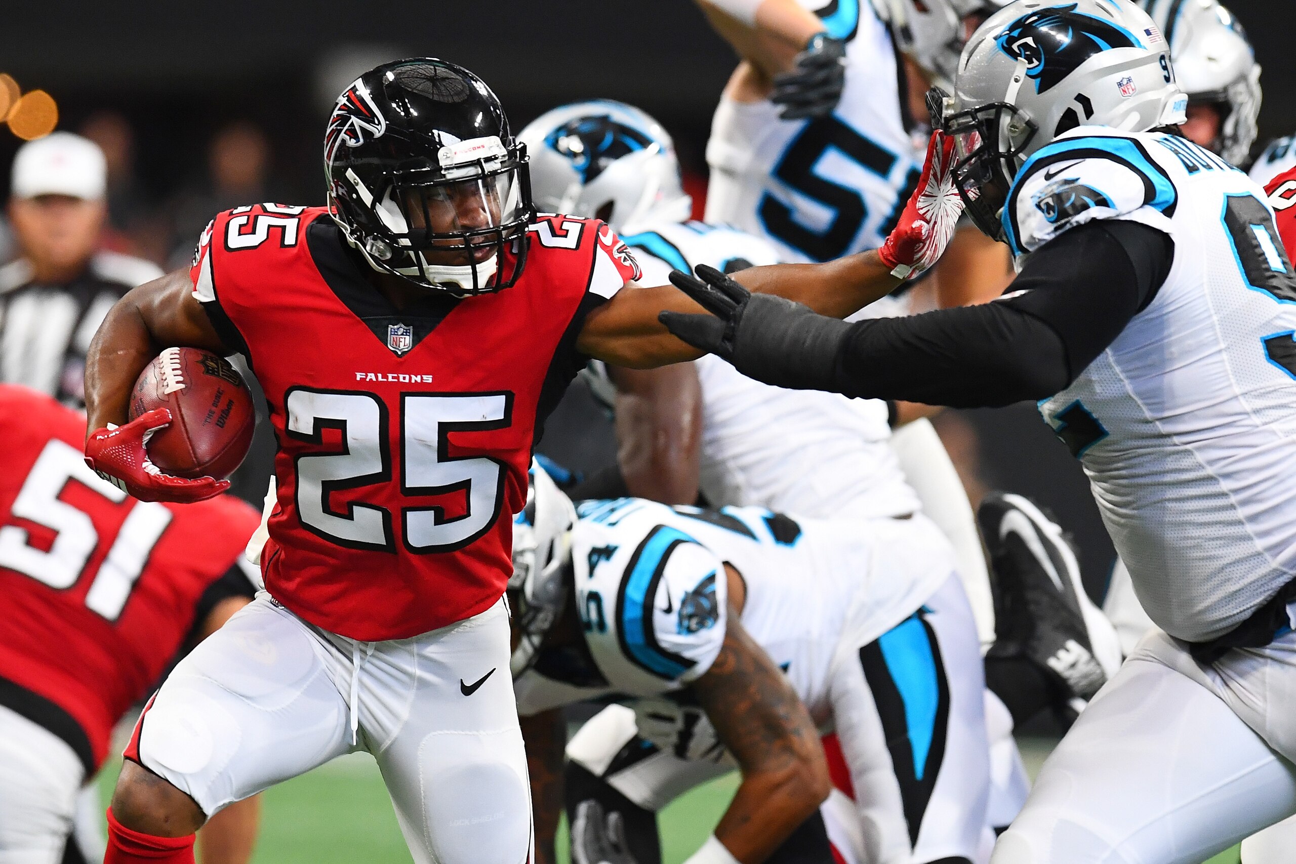 ATLANTA, GA - SEPTEMBER 16: Ito Smith #25 of the Atlanta Falcons stiff arms Vernon Butler #92 of the Carolina Panthers during the first half at Mercedes-Benz Stadium on September 16, 2018 in Atlanta, Georgia. (Photo by Scott Cunningham/Getty Images)