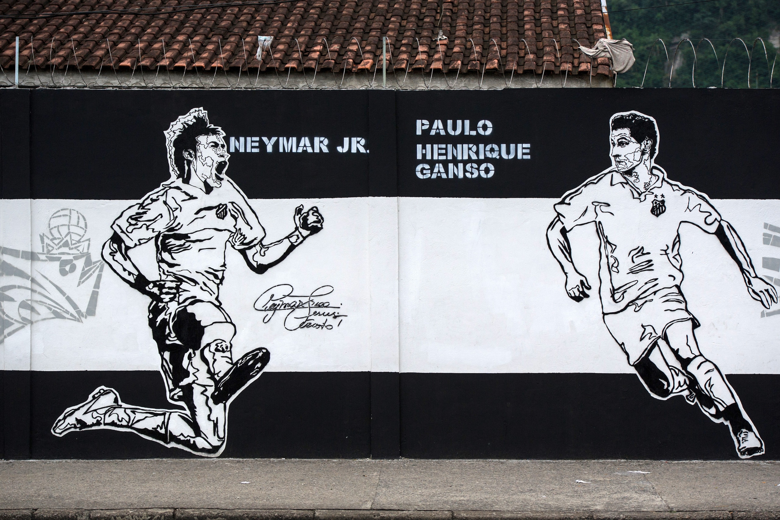 View of a wall of Santos's training facility painted with the portraits of players Neymar (L) and Ganso to celebrate the 100 anniversary of the club in Santos, Brazil on April 15, 2012. AFP PHOTO/Yasuyoshi CHIBA (Photo credit should read YASUYOSHI CHIBA/A