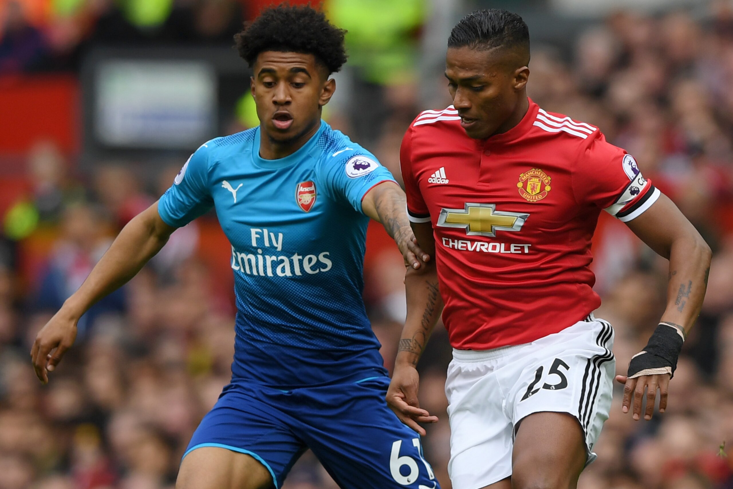 MANCHESTER, ENGLAND - APRIL 29:  Antonio Valencia of Manchester United is challenged by Reiss Nelson of Arsenal during the Premier League match between Manchester United and Arsenal at Old Trafford on April 29, 2018 in Manchester, England.  (Photo by Shau
