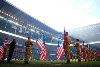 LONDON, ENGLAND - OCTOBER 02:  Members of the armed forces hold the national flags of the United Kingdom and the United States before the start of the during the NFL game between Indianapolis Colts and Jacksonville Jaguars at Wembley Stadium on October 2,