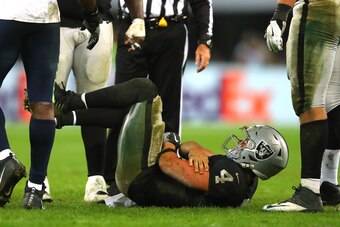 LONDON, ENGLAND - OCTOBER 14:  Derek Carr of the Oakland Raiders is injured in a tackle during the NFL International Series game between Seattle Seahawks and Oakland Raiders at Wembley Stadium on October 14, 2018 in London, England.  (Photo by Warren Litt