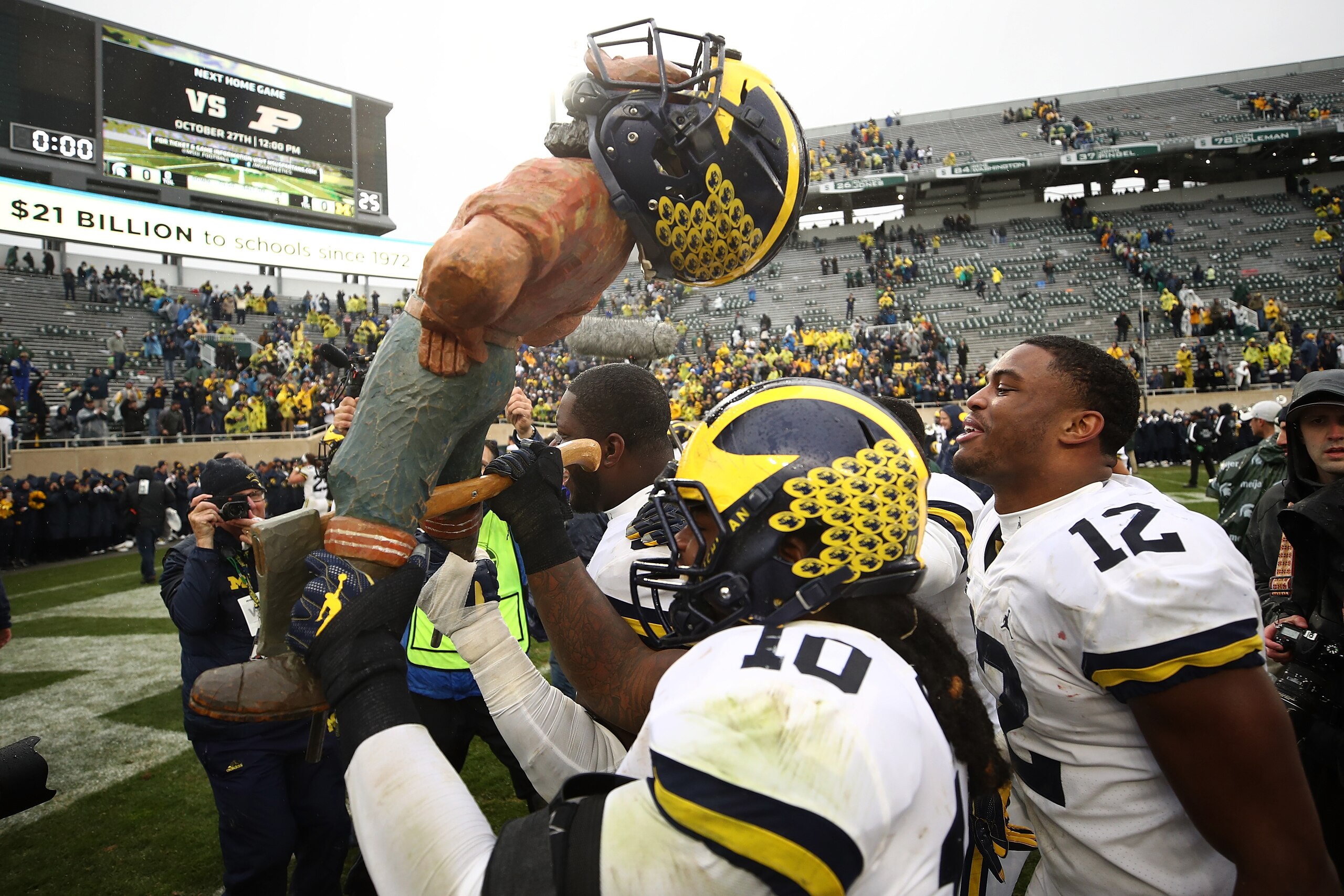 EAST LANSING, MI - OCTOBER 20: Devin Bush #10 of the Michigan Wolverines carries the Paul Bunyan trophy off the field after beating the Michigan State Spartans 21-7 at Spartan Stadium on October 20, 2018 in East Lansing, Michigan. (Photo by Gregory Shamus