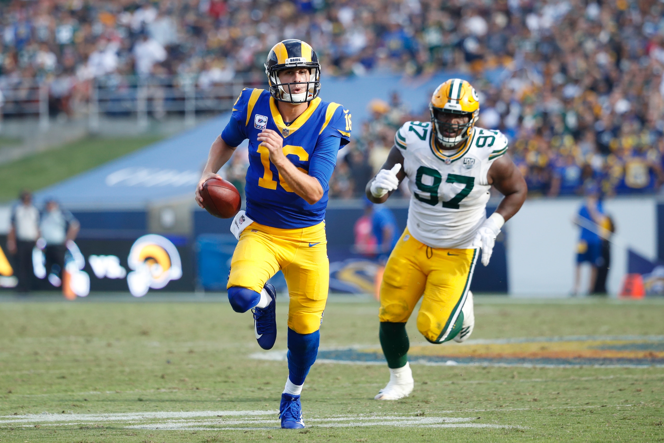 LOS ANGELES, CA - OCTOBER 28: Jared Goff #16 of the Los Angeles Rams runs the ball ahead of pressure from Kenny Clark #97 of the Green Bay Packers during the game at Los Angeles Memorial Coliseum on October 28, 2018 in Los Angeles, California. (Photo by J