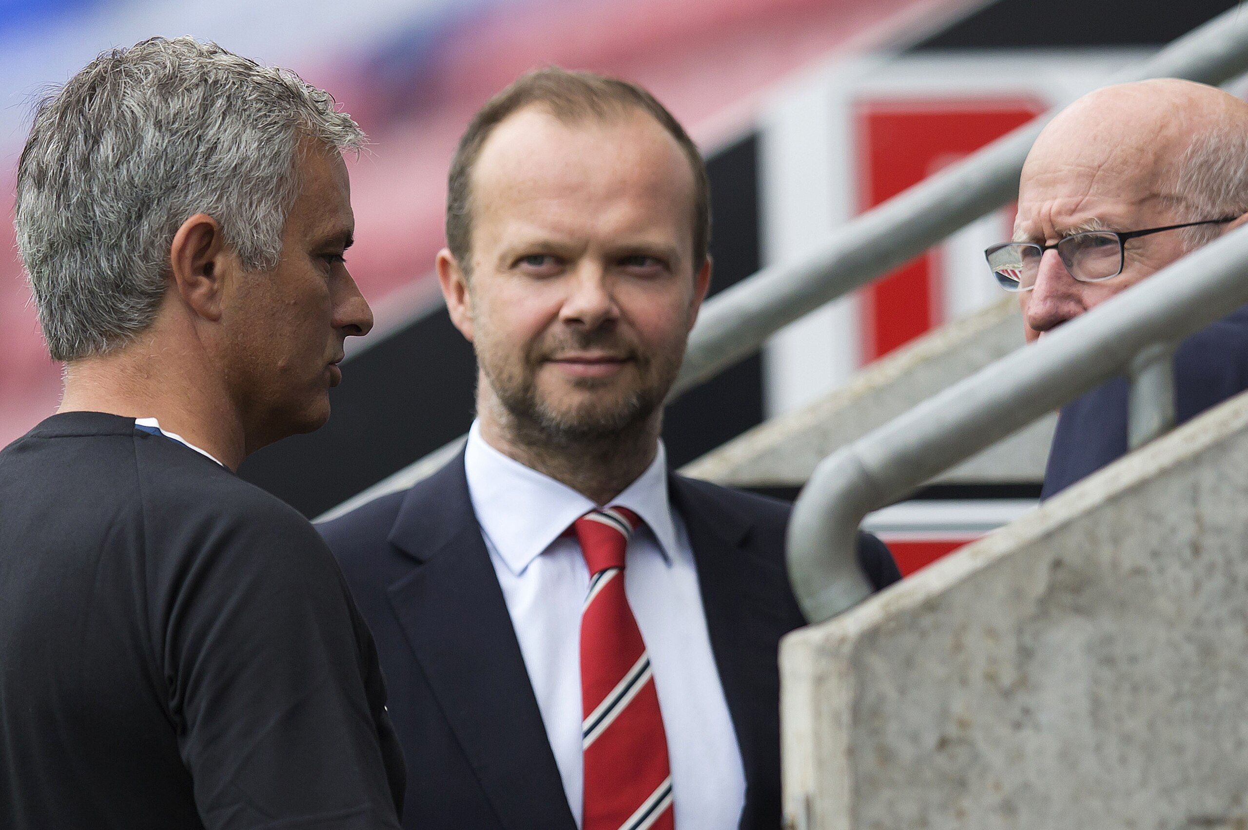 Manchester United's executive vice-chairman Ed Woodward (C) listens as Manchester United's Portuguese manager Jose Mourinho (L) talks with former Manchester United player Bobby Charlton following the pre-season friendly football match between Wigan Athlet