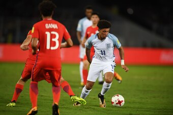 England's Jadon Sancho(R) and Chile's Willian Gama fight for the ball during the group stage football match between England and Chile in the FIFA U-17 World Cup at the Salt Lake Stadium in Kolkata on October 8, 2017. / AFP PHOTO / Dibyangshu SARKAR       