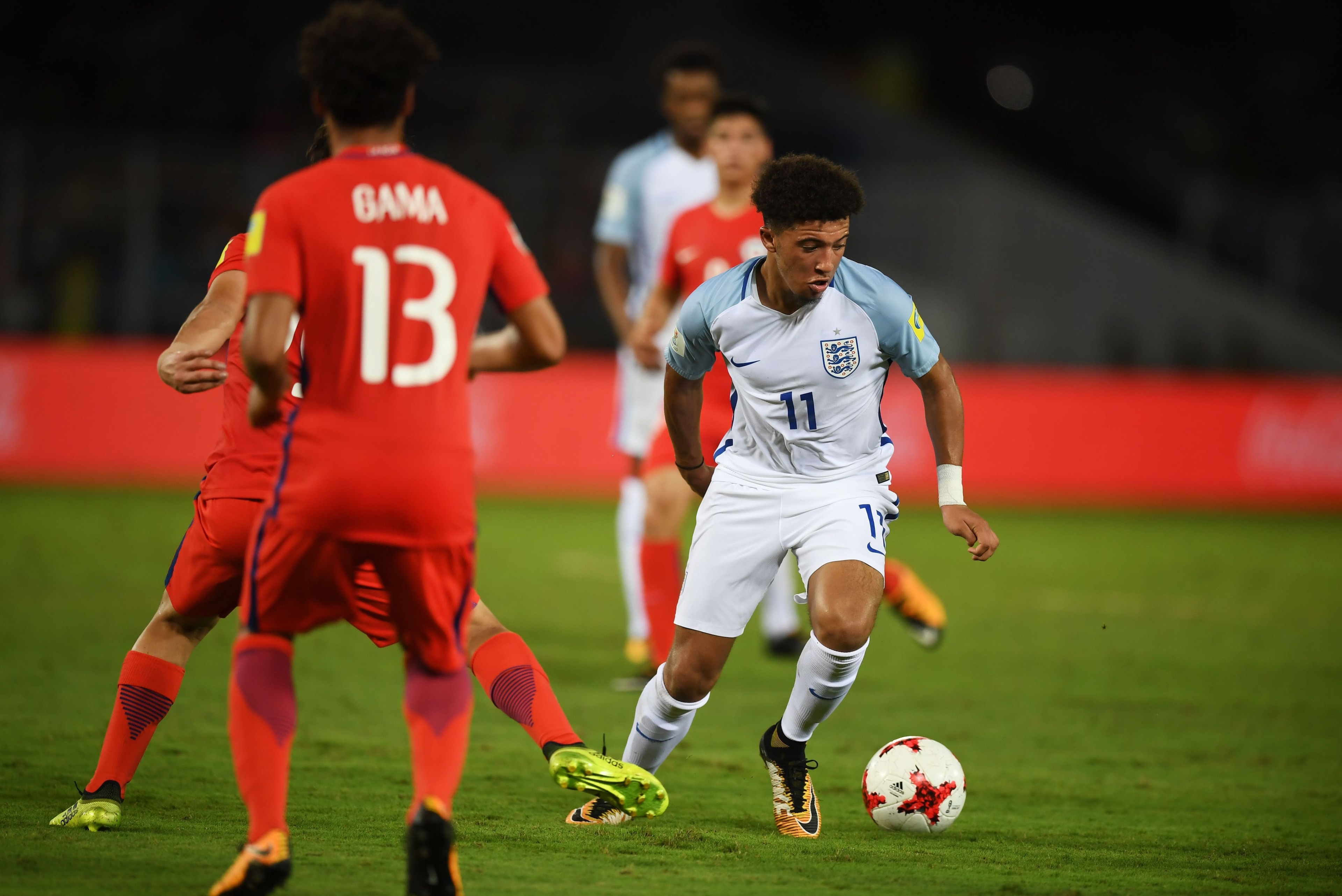 England's Jadon Sancho(R) and Chile's Willian Gama fight for the ball during the group stage football match between England and Chile in the FIFA U-17 World Cup at the Salt Lake Stadium in Kolkata on October 8, 2017. / AFP PHOTO / Dibyangshu SARKAR       
