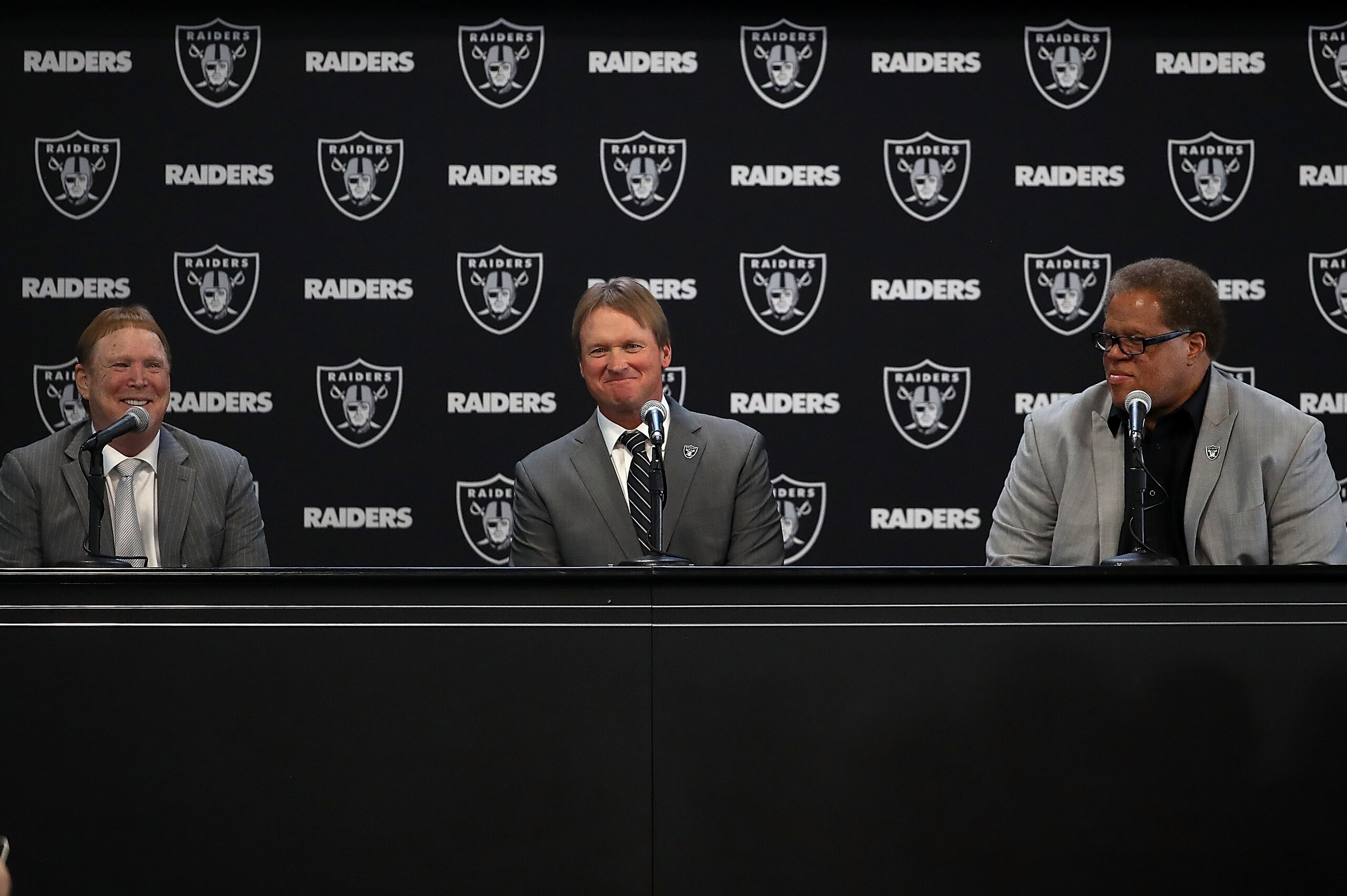 ALAMEDA, CA - JANUARY 09:  (L-R) Oakland Raiders owner Mark Davis, Oakland Raiders new head coach Jon Gruden and Oakland Raiders general manager Reggie McKenzie look on during a news conference at Oakland Raiders headquarters on January 9, 2018 in Alameda