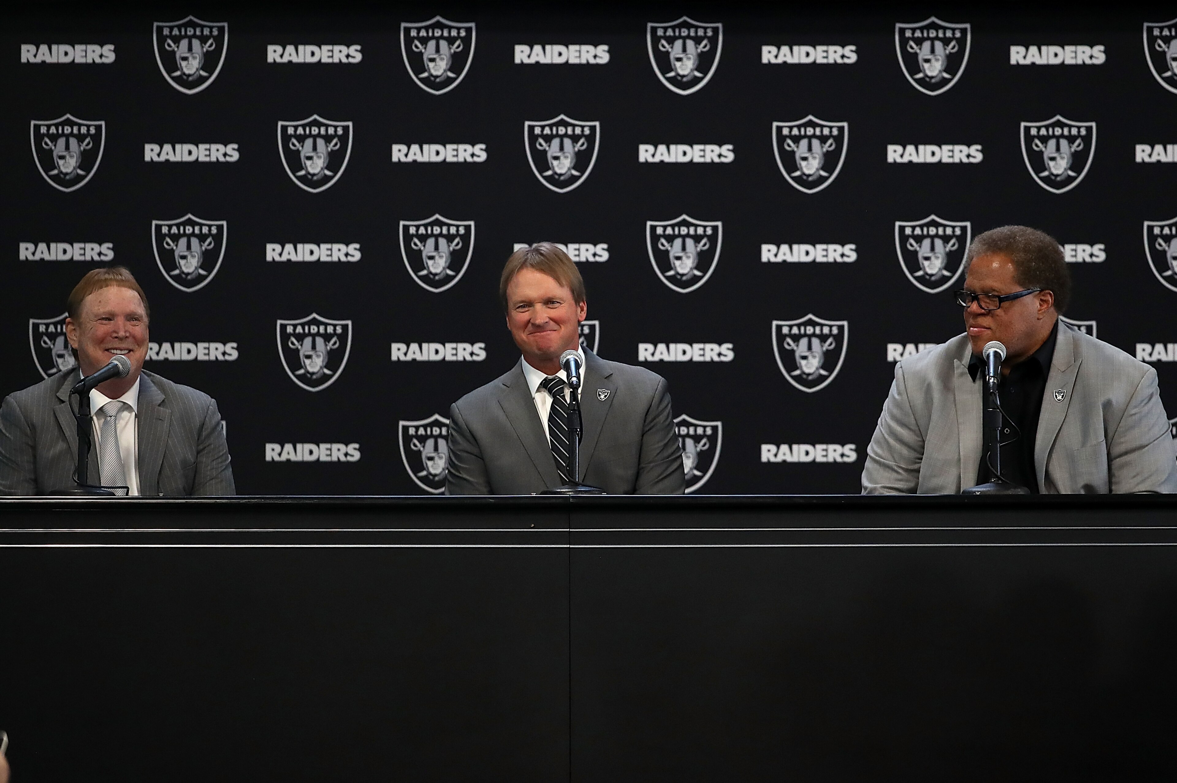 ALAMEDA, CA - JANUARY 09:  (L-R) Oakland Raiders owner Mark Davis, Oakland Raiders new head coach Jon Gruden and Oakland Raiders general manager Reggie McKenzie look on during a news conference at Oakland Raiders headquarters on January 9, 2018 in Alameda