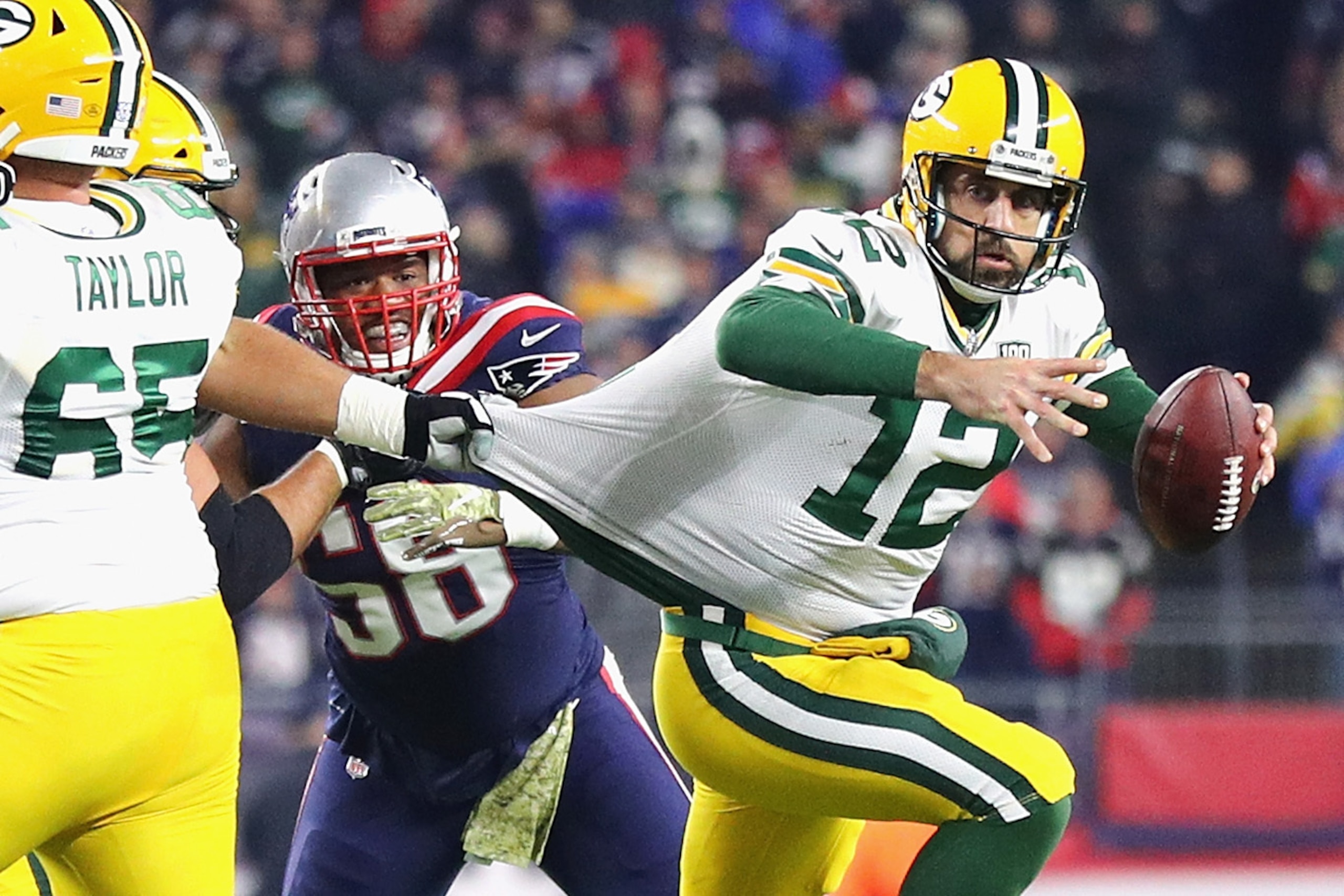 FOXBOROUGH, MA - NOVEMBER 04: Aaron Rodgers #12 of the Green Bay Packers looks to pass the ball as his jersey is grabbed by Lawrence Guy #93 of the New England Patriots (not pictured) during the second half at Gillette Stadium on November 4, 2018 in Foxb FOXBOROUGH, MA - NOVEMBER 04: Aaron Rodgers #12 of the Green Bay Packers looks to pass the ball as his jersey is grabbed by Lawrence Guy #93 of the New England Patriots (not pictured) during the second half at Gillette Stadium on November 4, 2018 in Foxb
