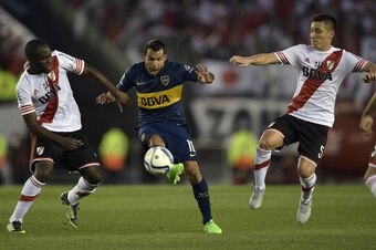 Boca Juniors' forward Carlos Tevez (C) vies for the ball with River Plate's defender Eder Alvarez Balanta (L) and midfielder Matias Kranevitter during their Argentine first division football match at the Monumental stadium in Buenos Aires, Argentina, on S